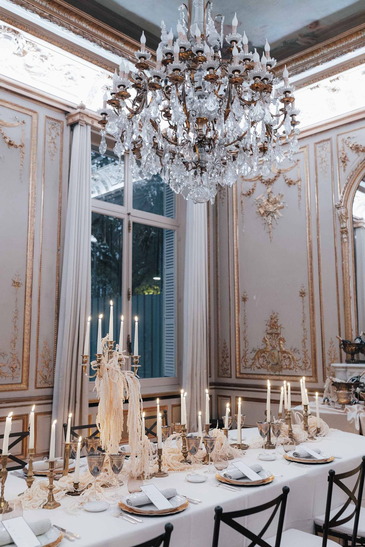 Empty ornate salon with tall windows and a chandelier at La Galerie Bourbon