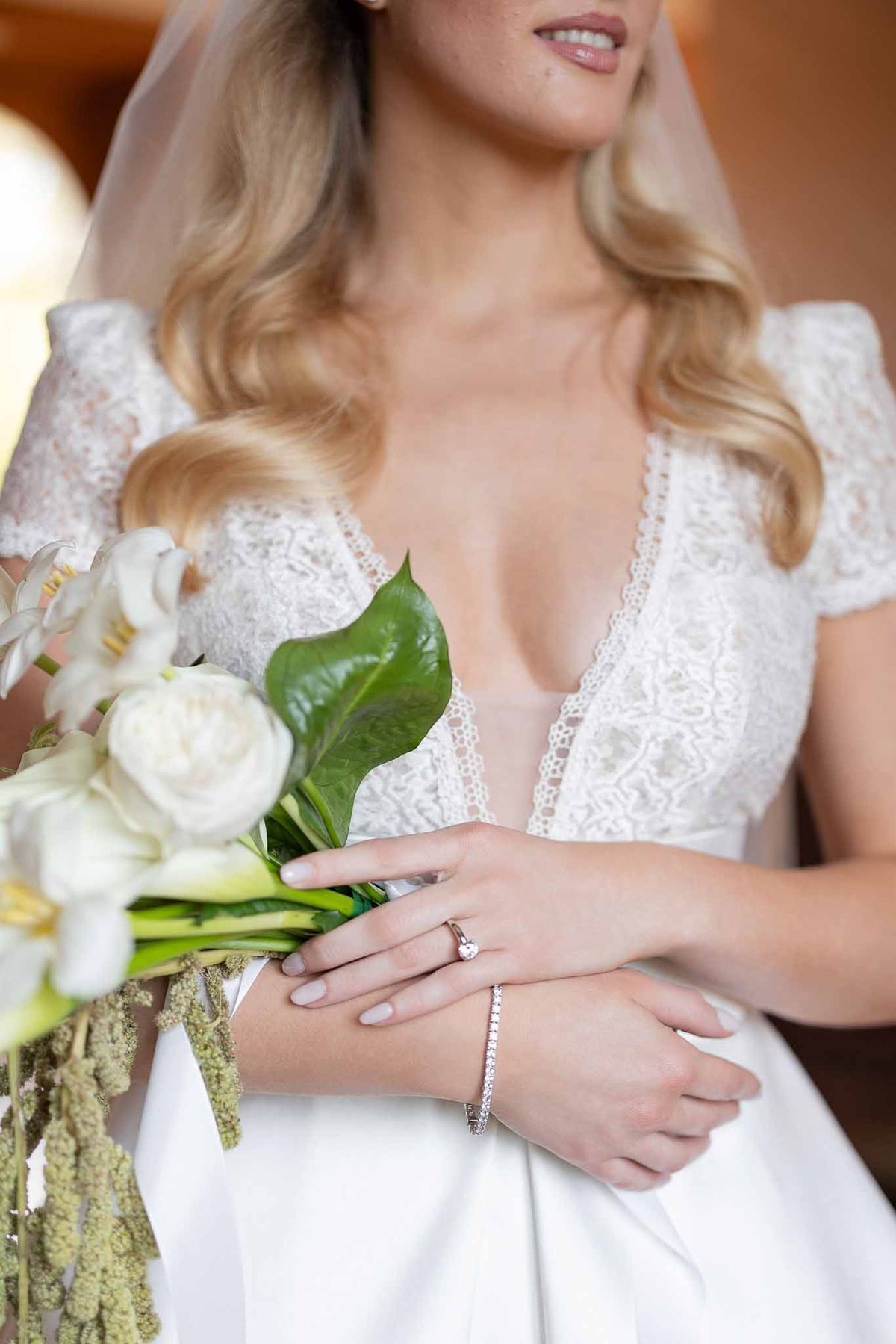 Bride holding calla lily bouquet with diamond bracelet at Château Comtesse Lafond