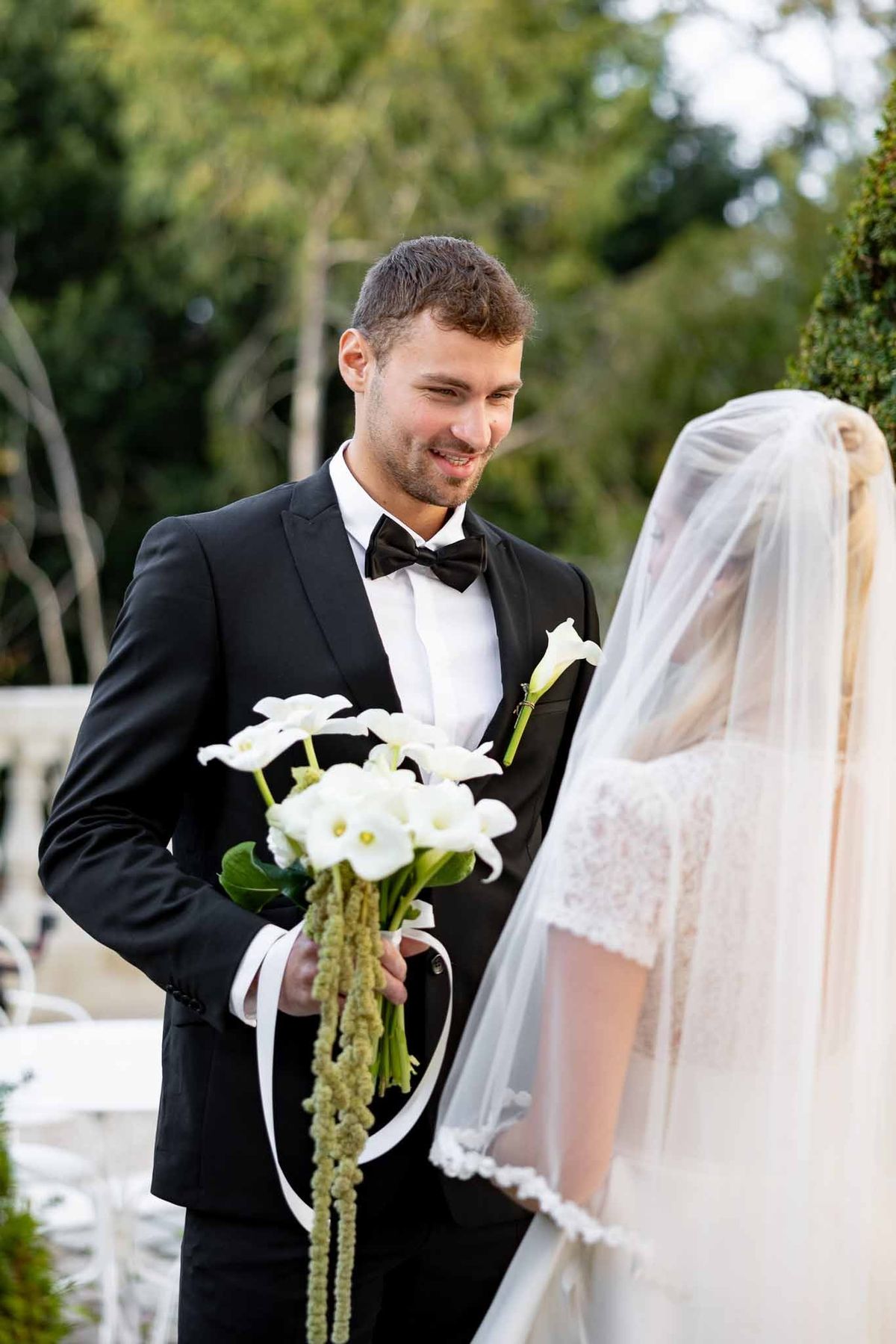 Groom seeing bride for first time during first look in garden at Château Comtesse Lafond