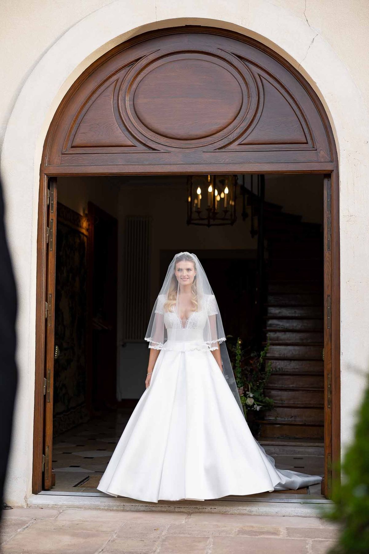 Bride standing in arched wooden doorway at Château Comtesse Lafond