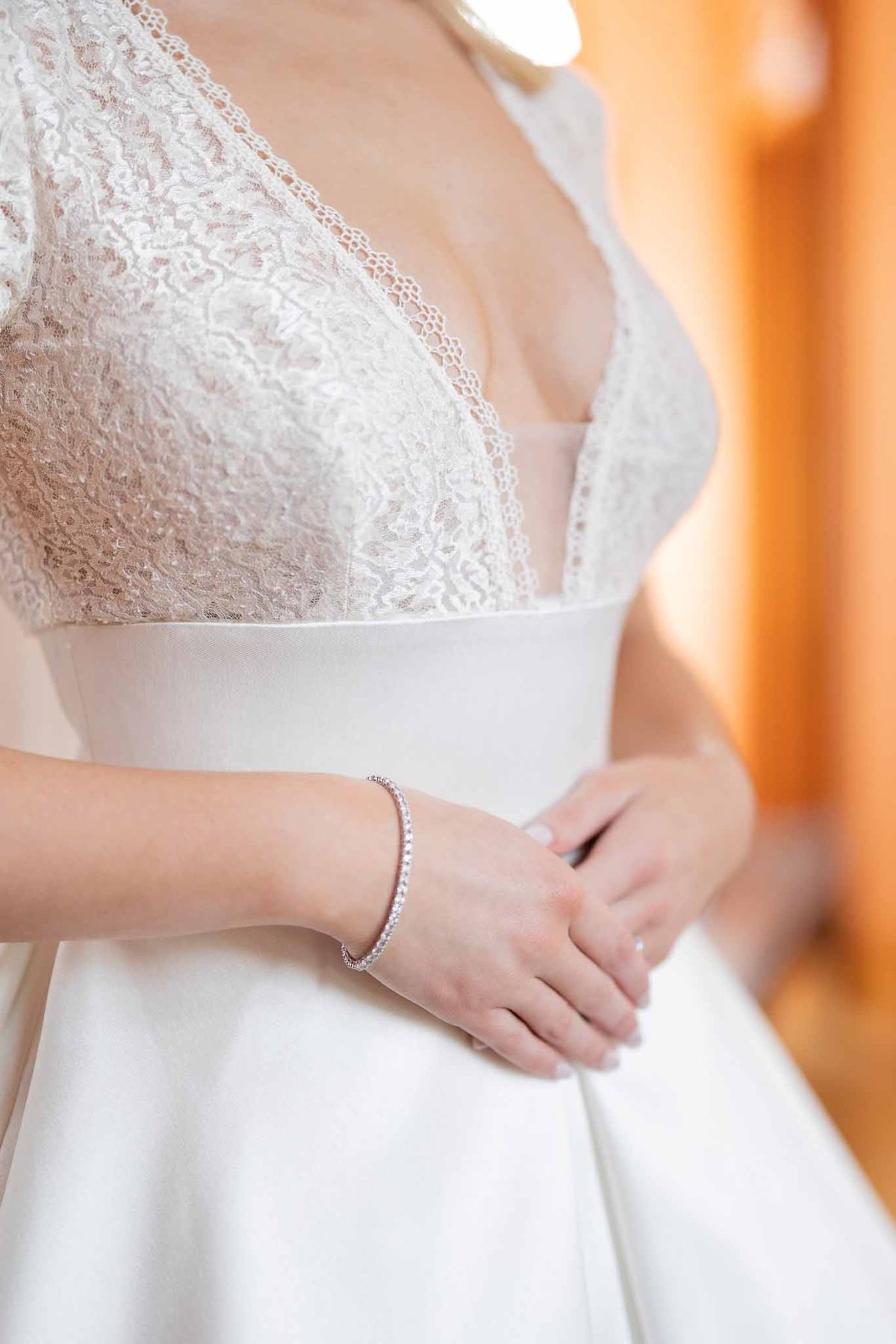 Close-up of bride's lace bodice and diamond bracelet at Château Comtesse Lafond
