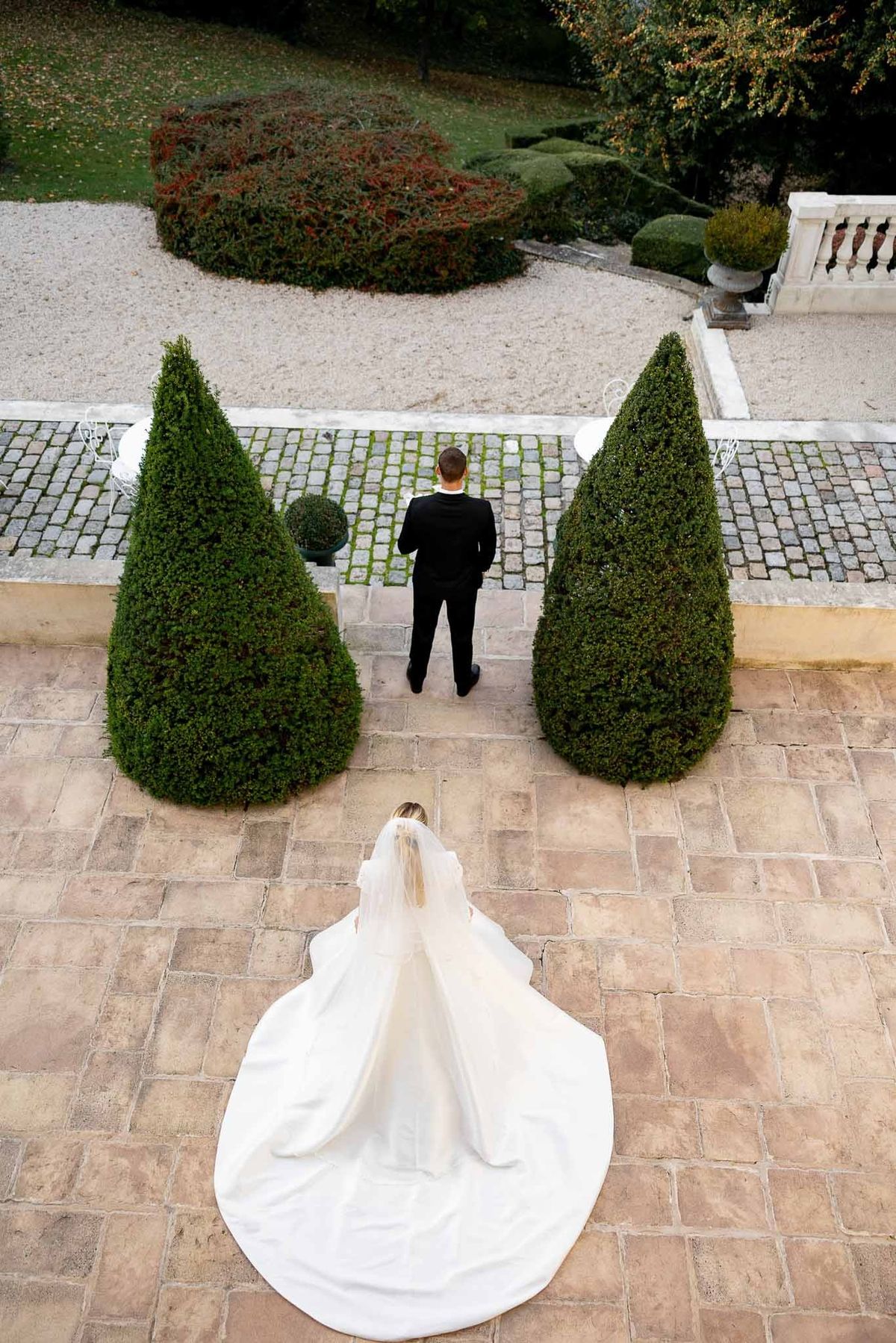 Aerial view of bride approaching groom for first look on terrace at Château Comtesse Lafond