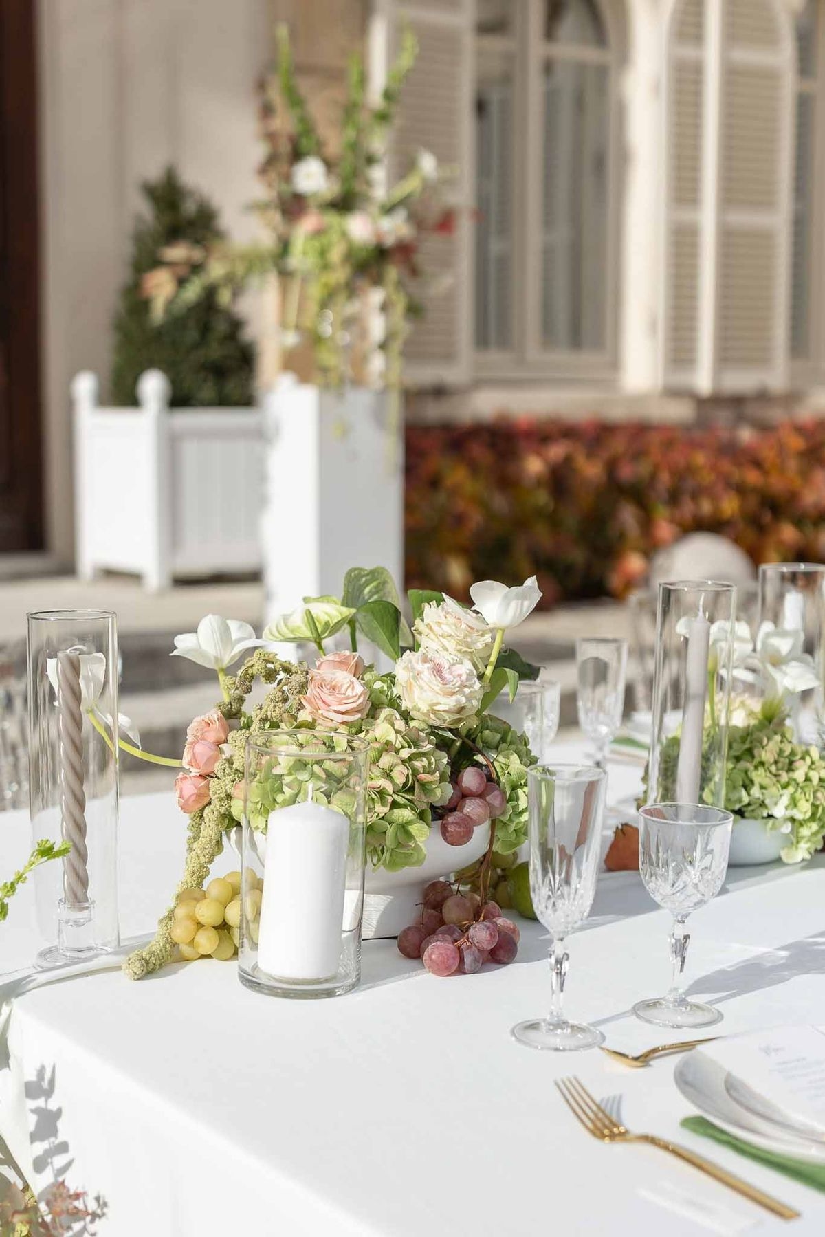 Close-up of blush rose and hydrangea centrepiece with grapes at Château Comtesse Lafond