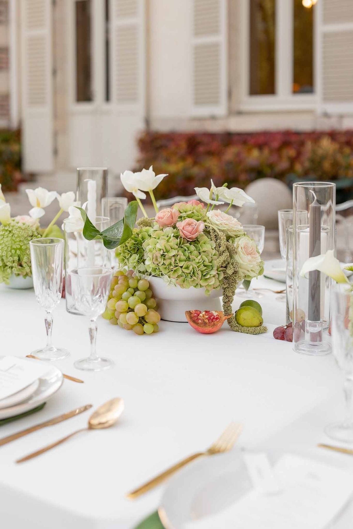 Reception table with green napkins, gold cutlery and fruit centrepiece at Château Comtesse Lafond