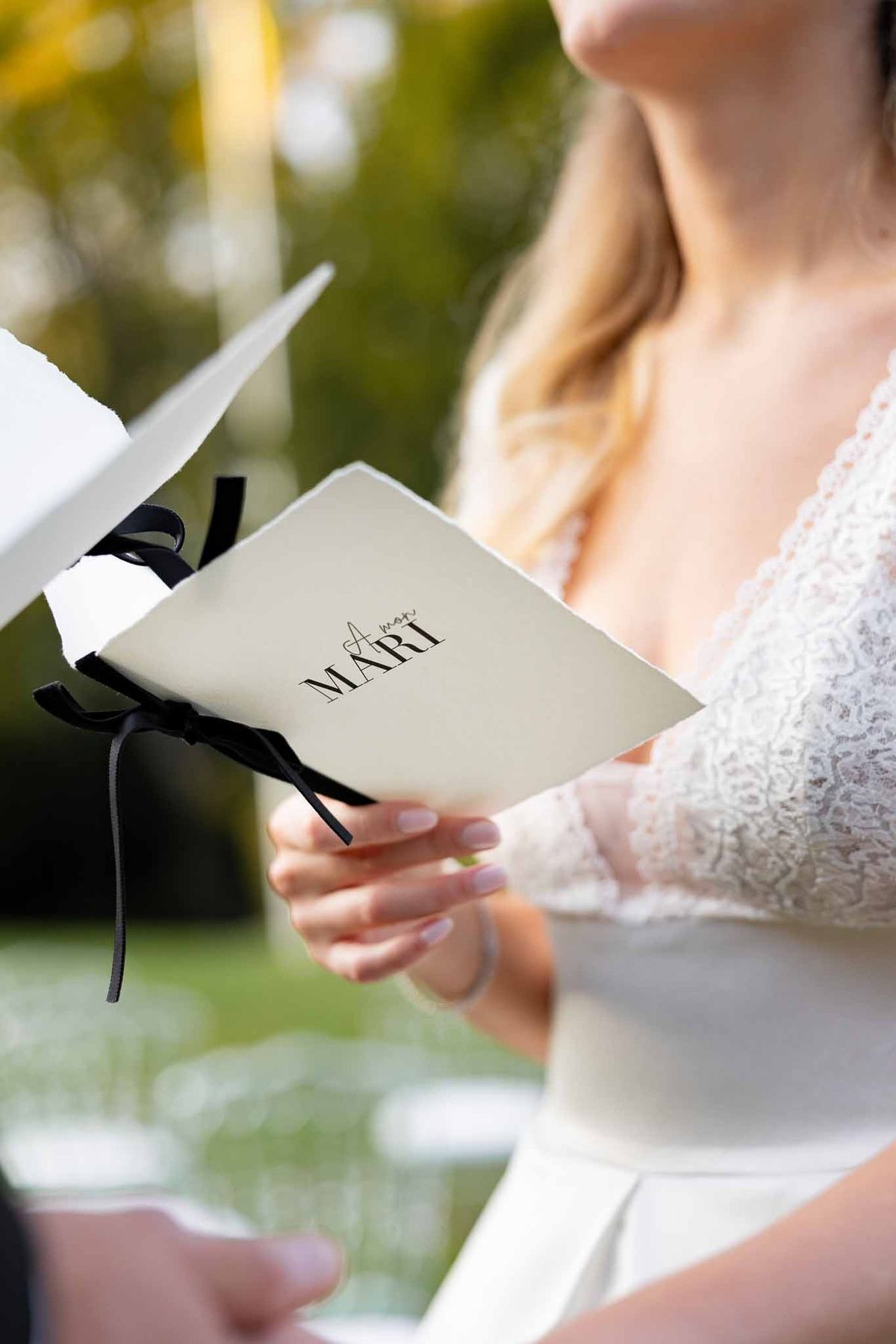 Bride reading personalised vow booklet during ceremony at Château Comtesse Lafond