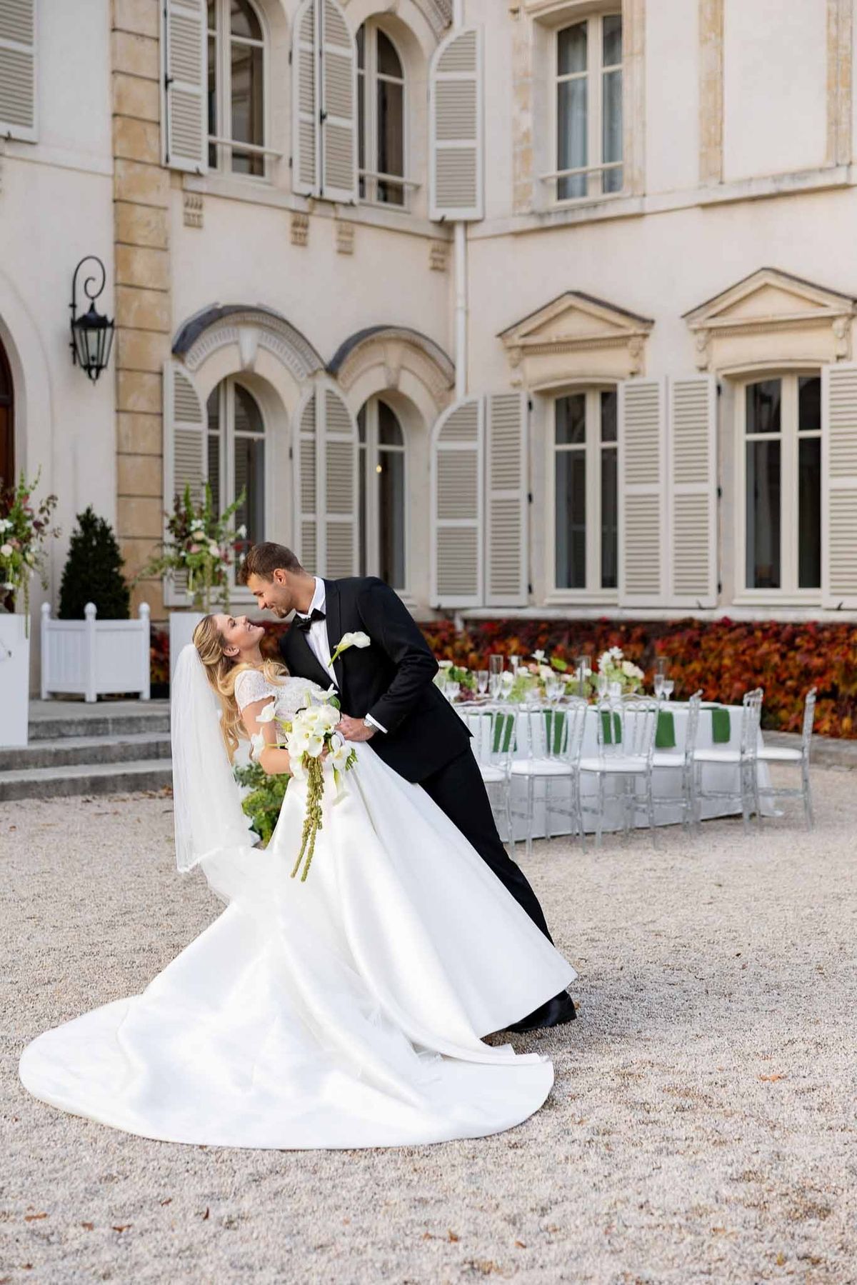Groom dipping bride for kiss in courtyard at Château Comtesse Lafond