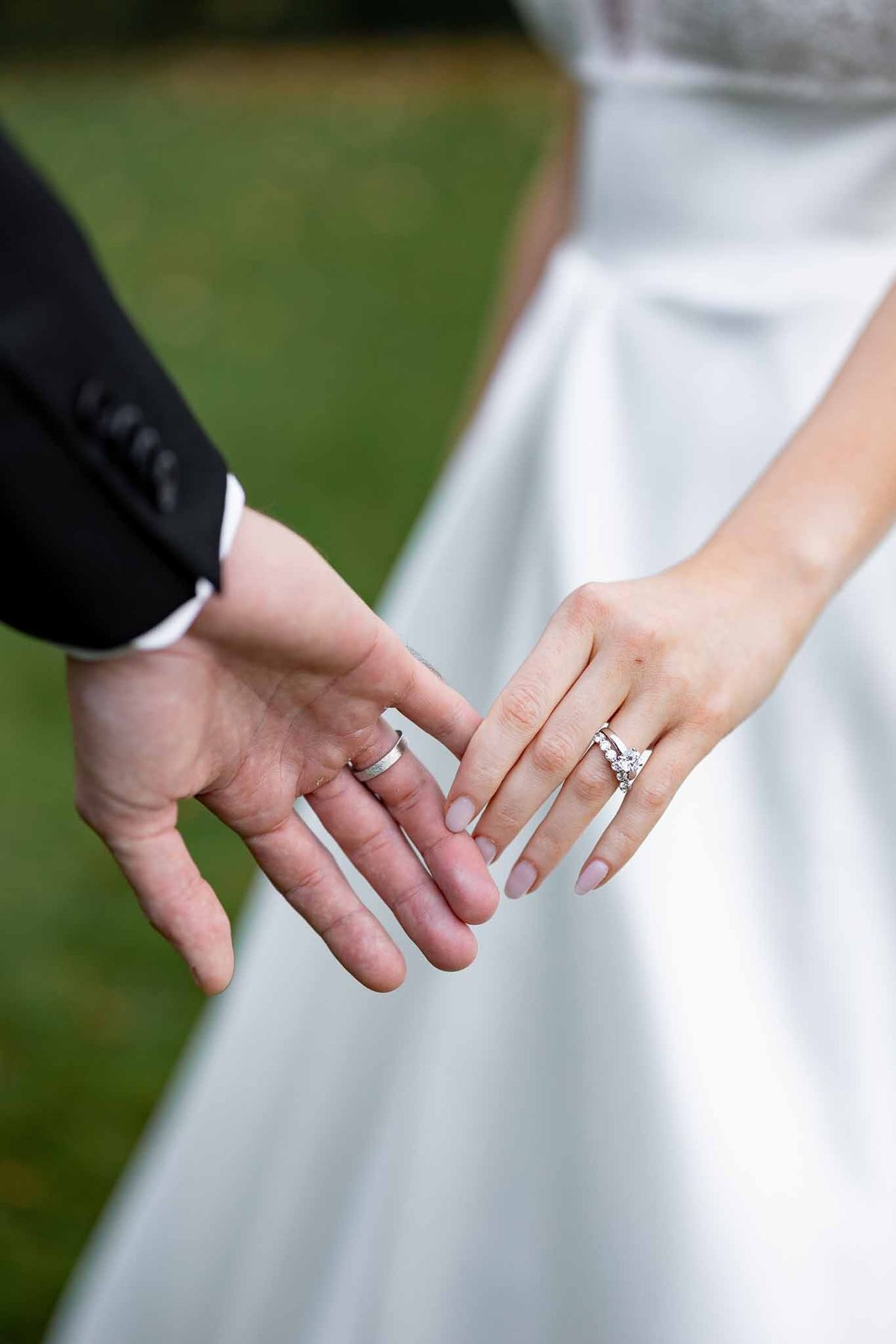Close-up of wedding rings on couple's hands at Château Comtesse Lafond