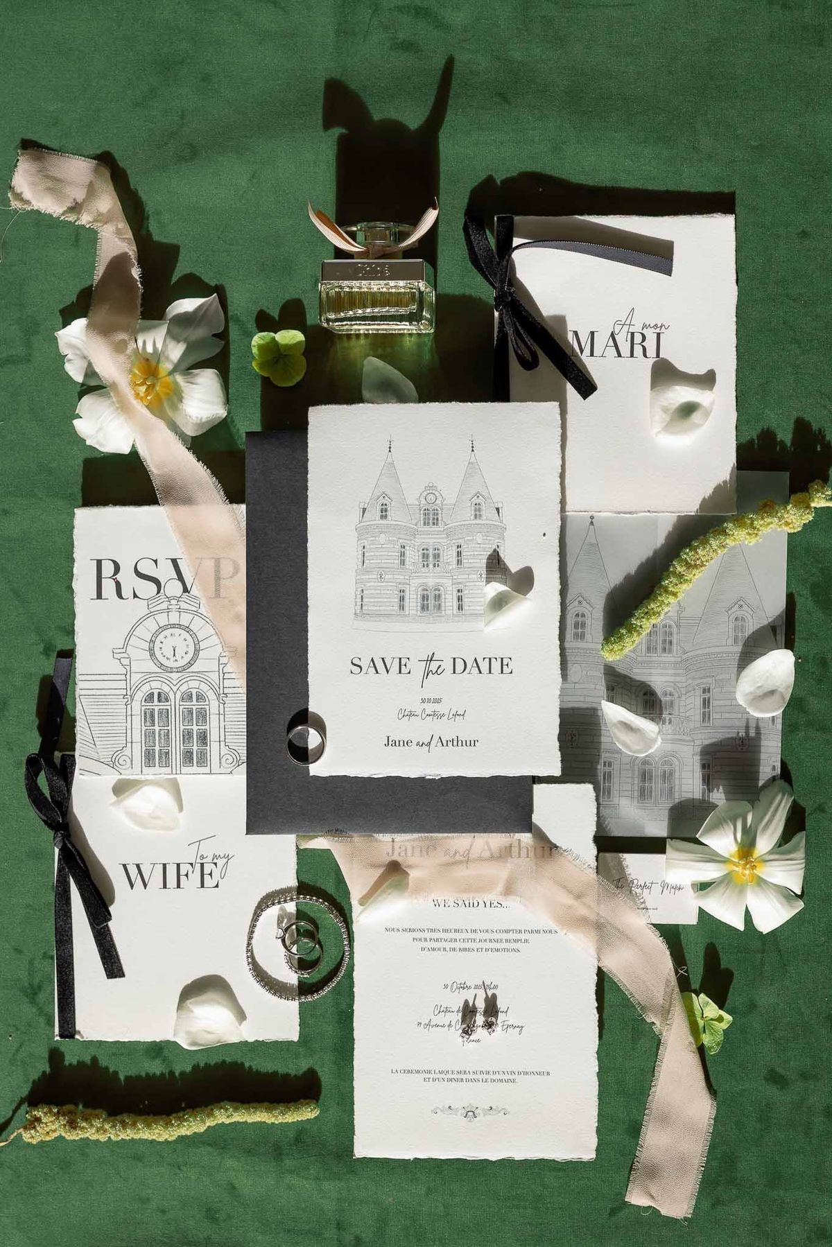 Complete wedding stationery flat lay with perfume and jewellery on green velvet at Château Comtesse Lafond