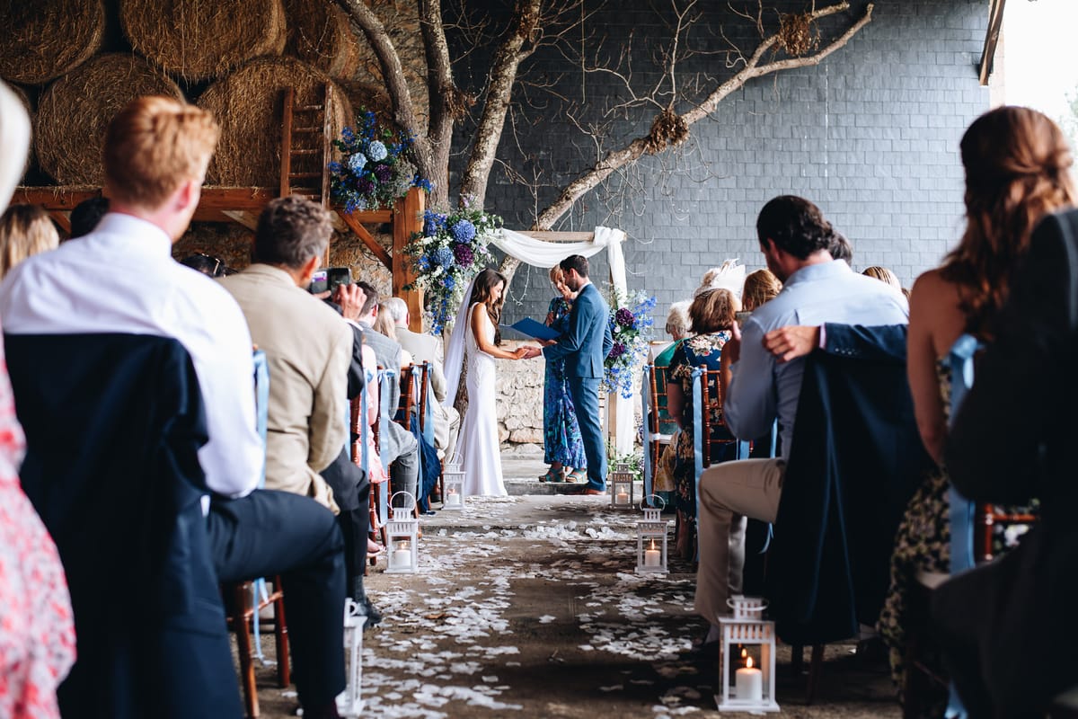 Couple exchanging vows with white roses