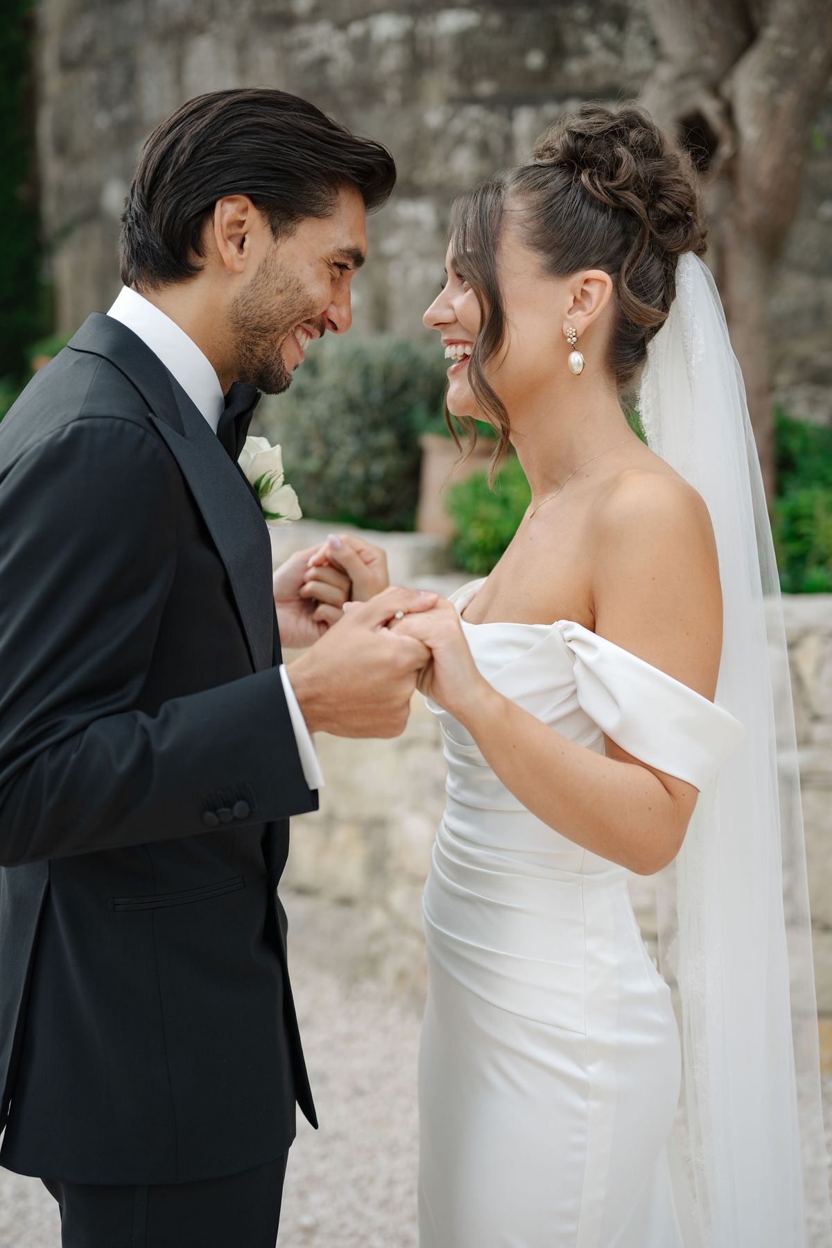 Bride and groom laughing while holding hands during couple portraits