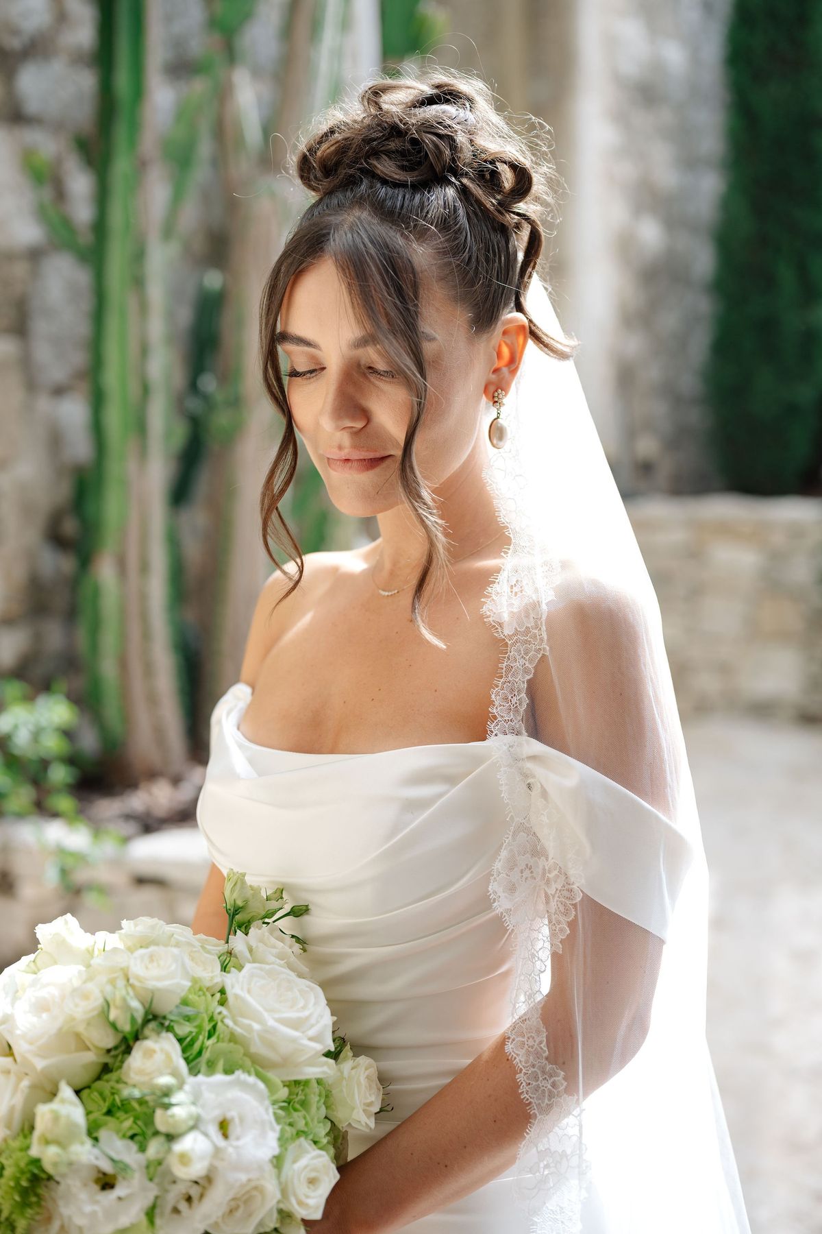 Close bridal portrait with tousled chignon and lace-trimmed veil