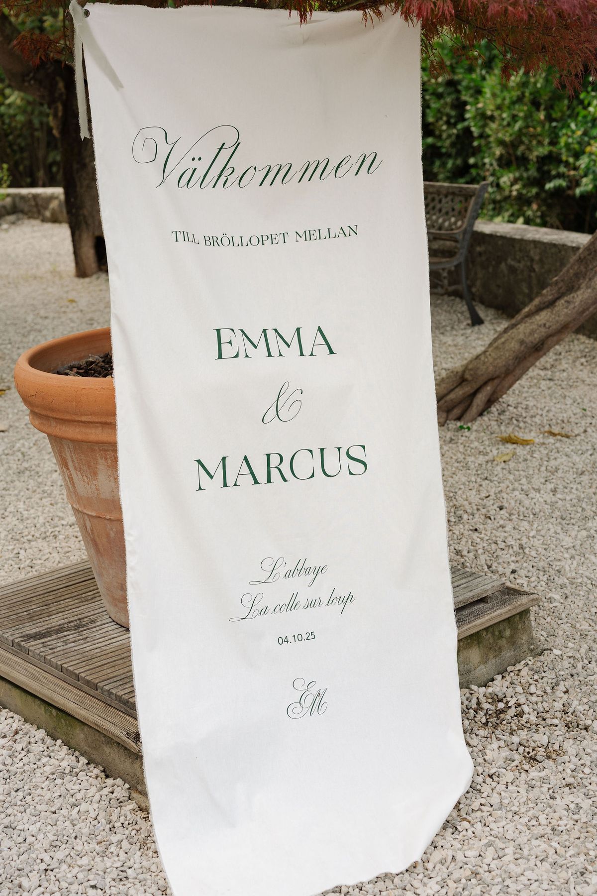 Cream fabric welcome banner with green calligraphy for outdoor ceremony