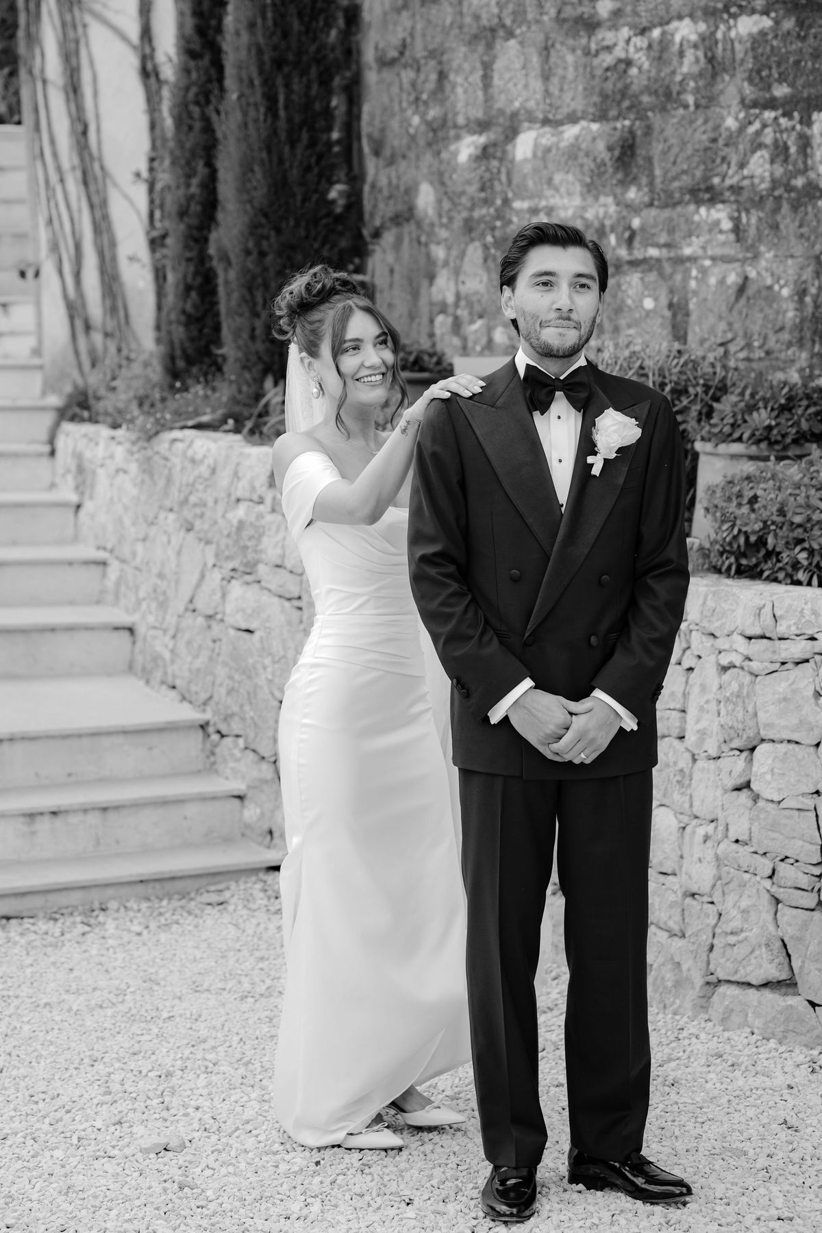 Black and white first look portrait of bride and groom in courtyard