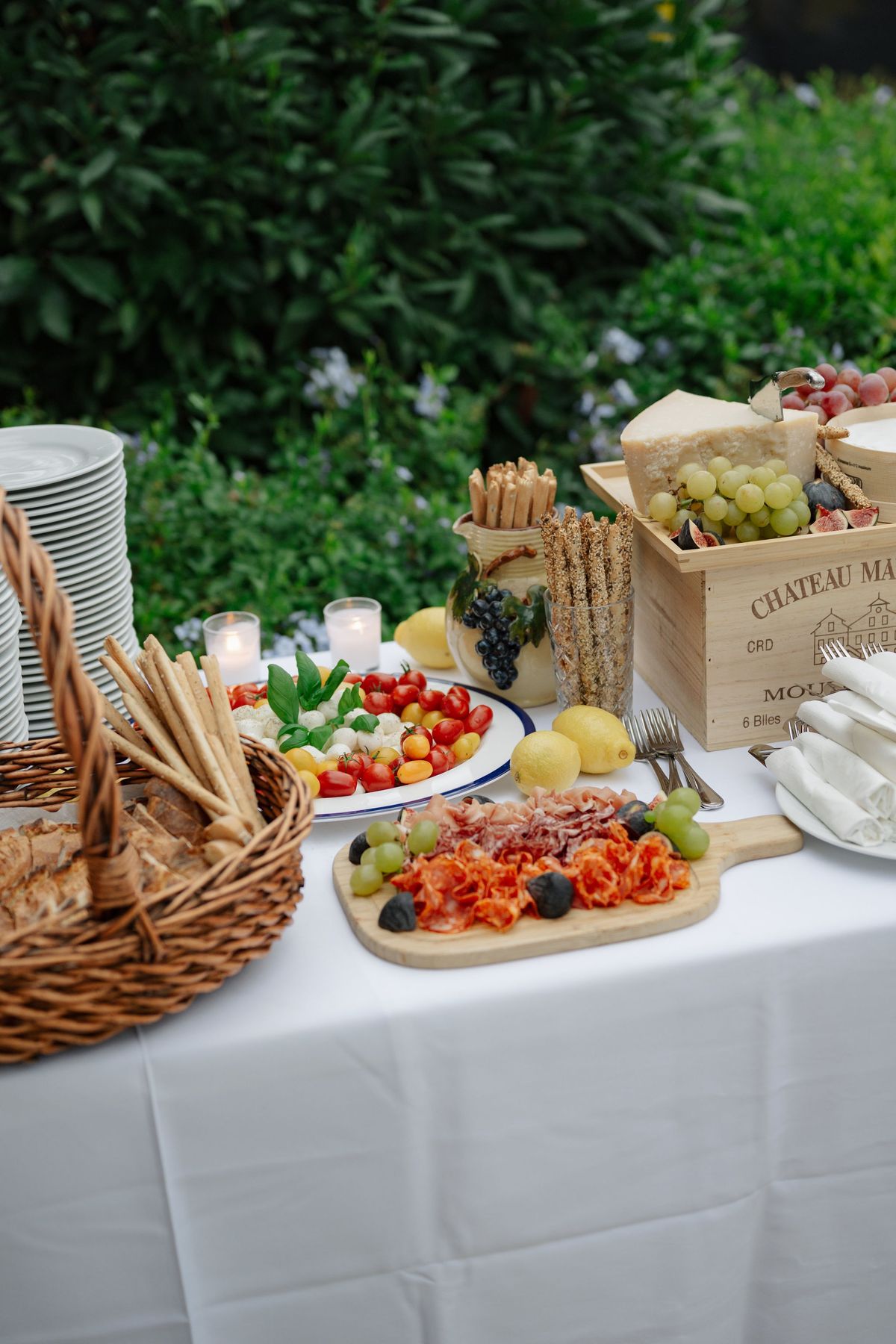 Antipasti spread with cheese, charcuterie, and bread on garden buffet