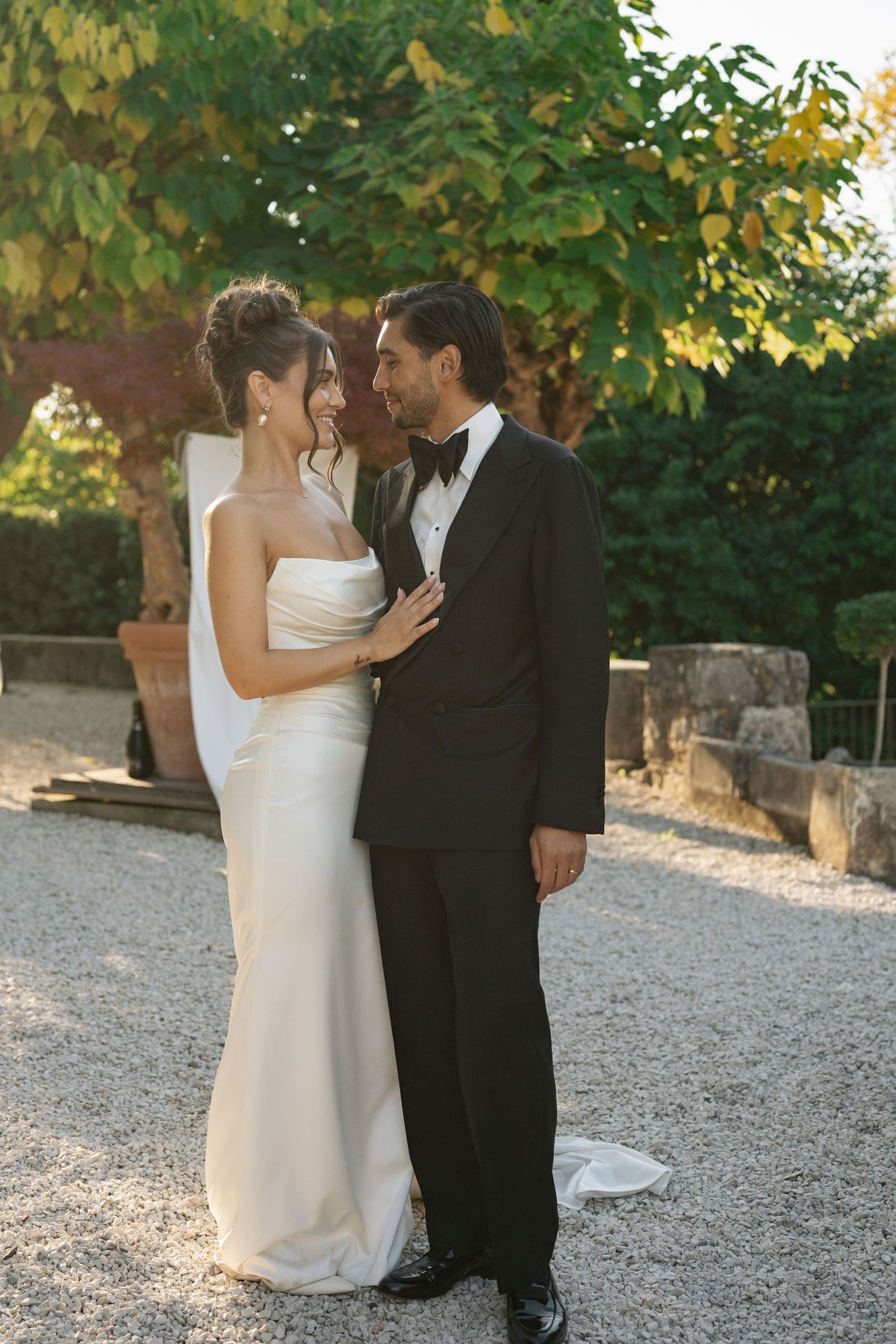 Couple gazing at each other in golden hour light on garden path