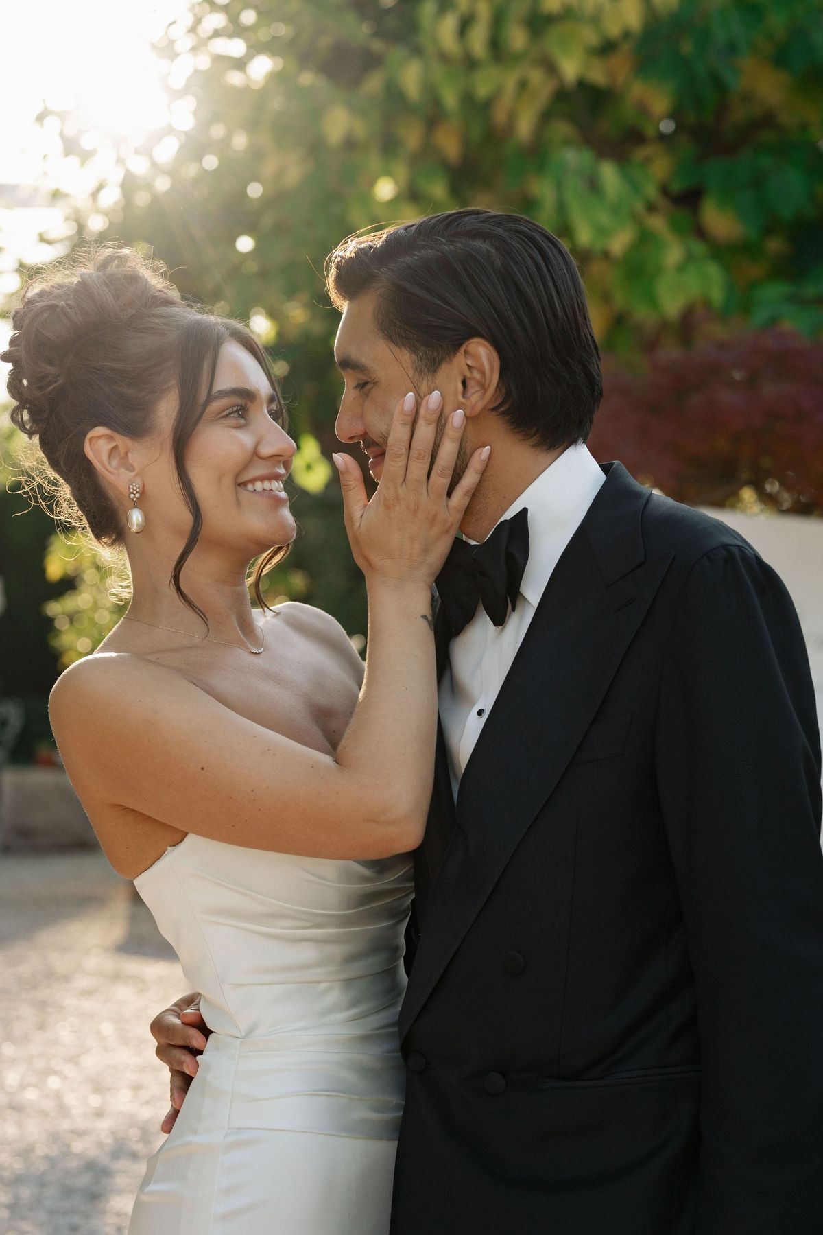 Bride holding groom's face during intimate golden hour portrait