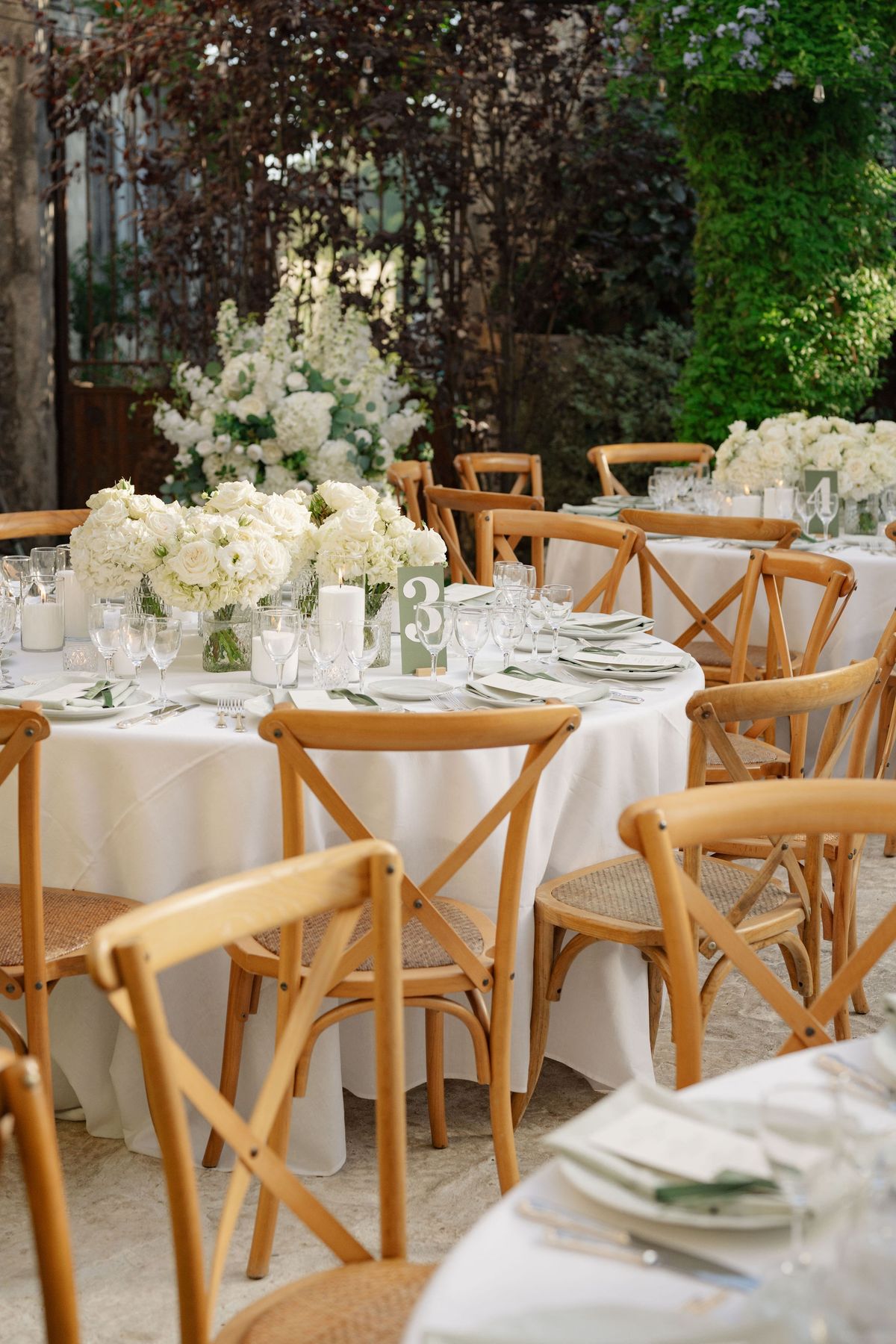 Cluster of reception tables with sage table numbers and white florals
