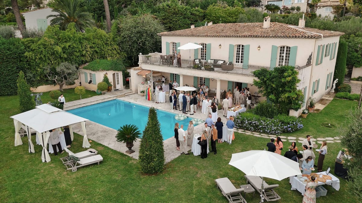 Drone view of cocktail hour guests around villa pool and terrace