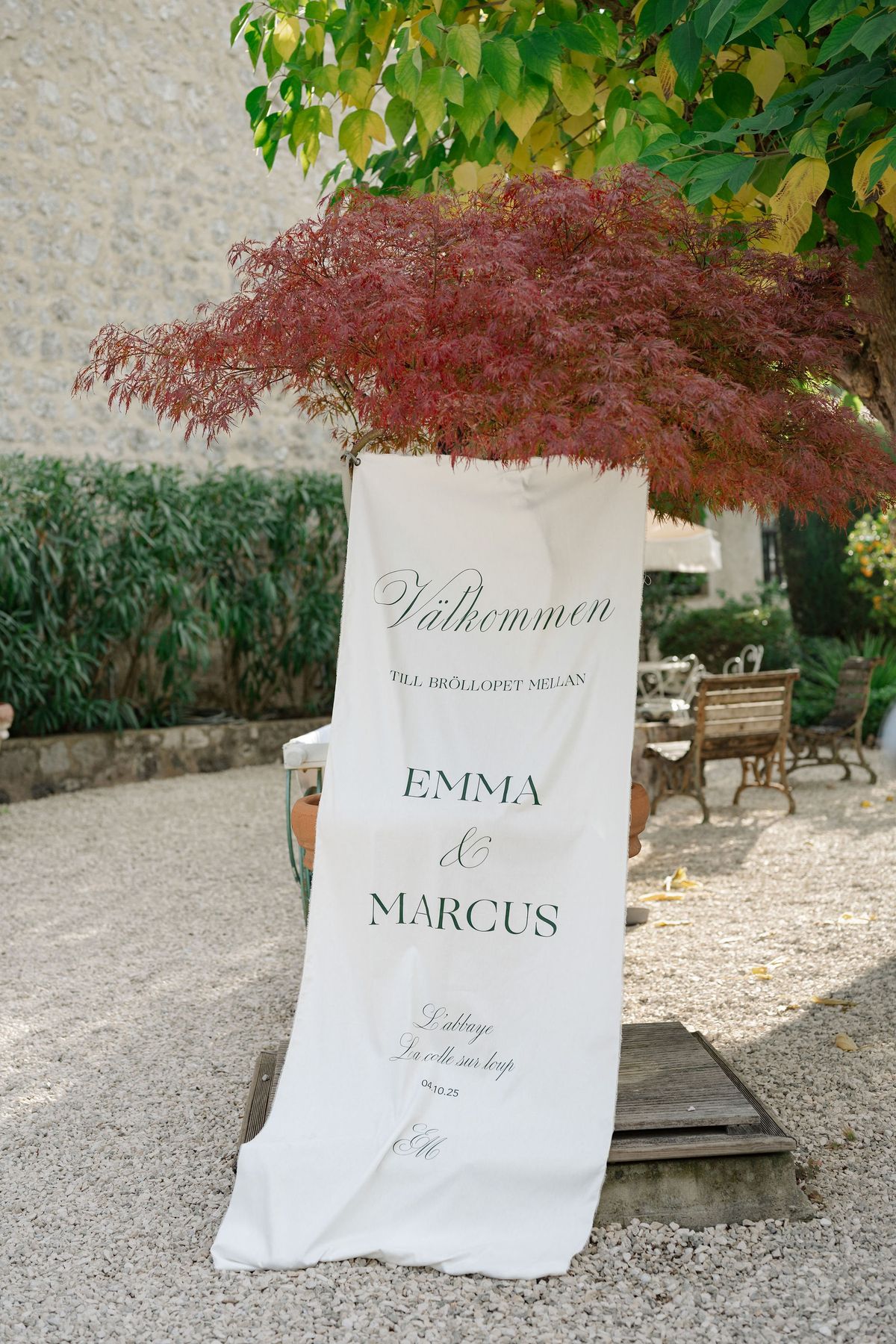 Welcome banner positioned beneath burgundy Japanese maple at venue