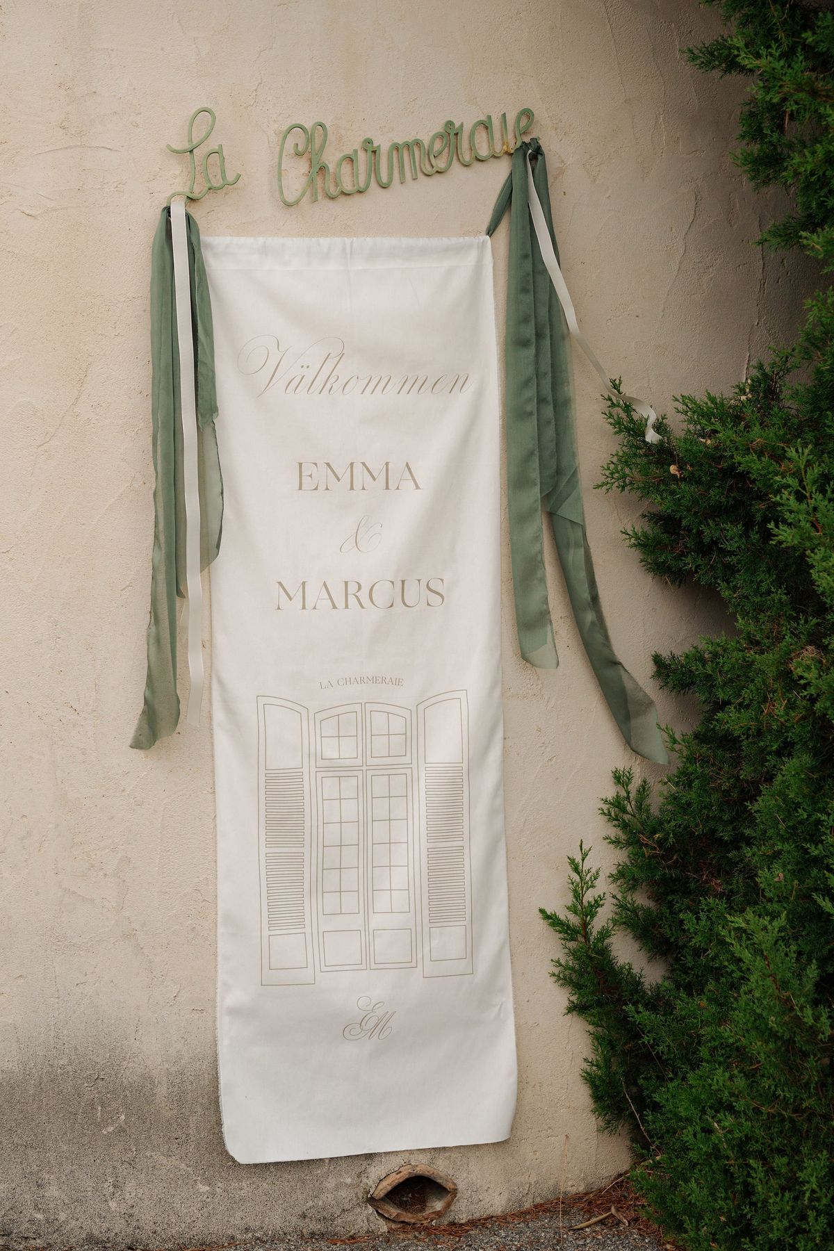 Cream banner with sage ribbons and venue line drawing on stone wall