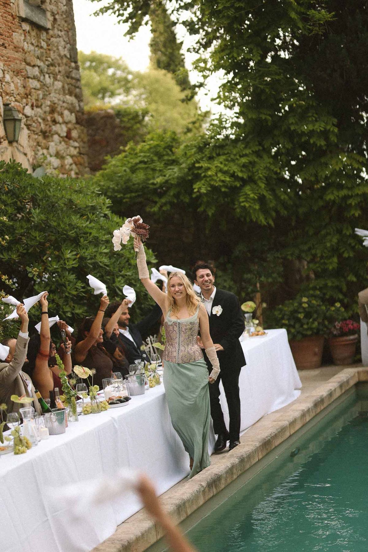 Couple walking past white-draped tables at reception at Chateau St Victor Lacoste