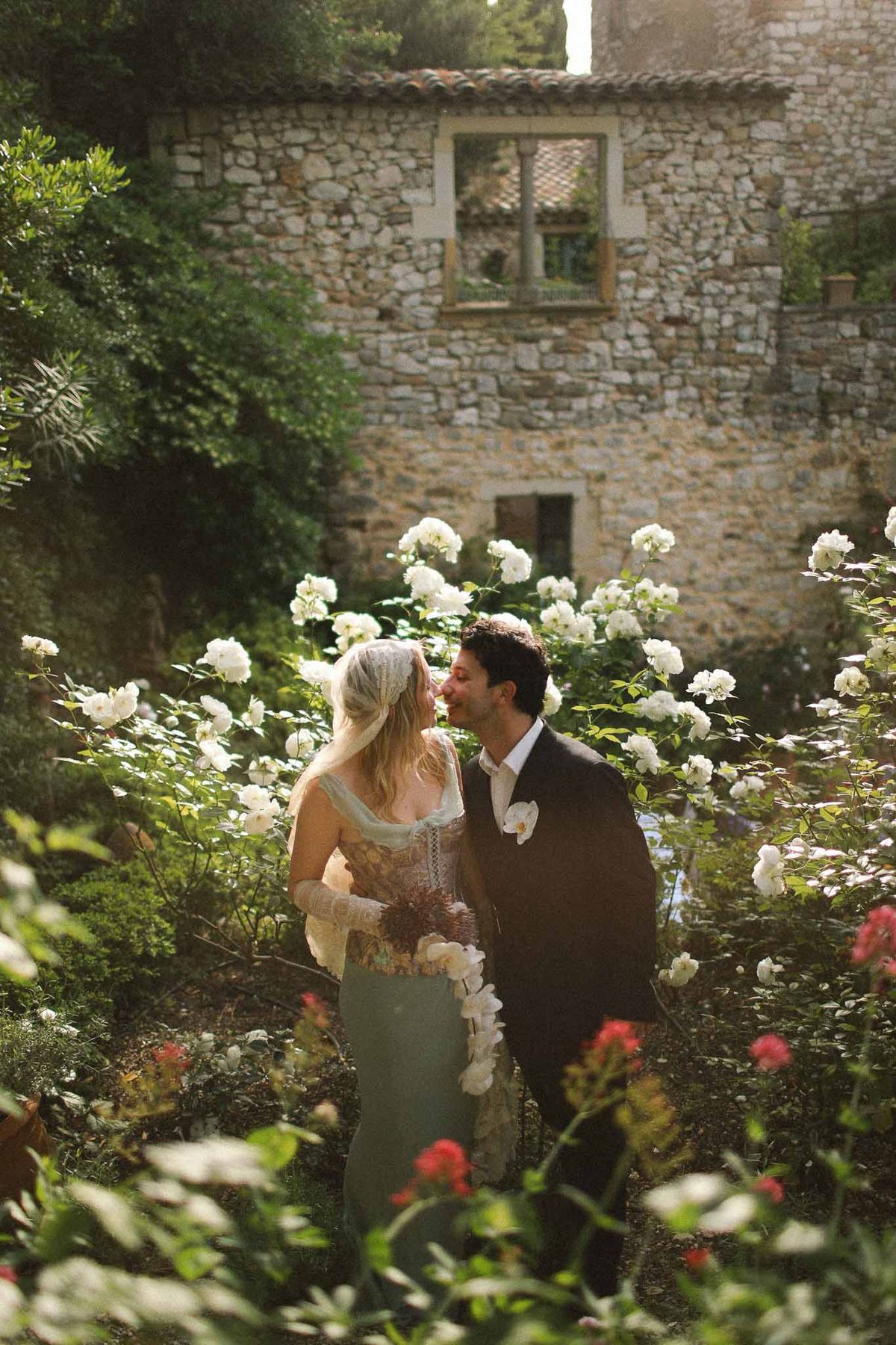 Couple sharing a kiss in the garden during golden hour at Chateau St Victor Lacoste