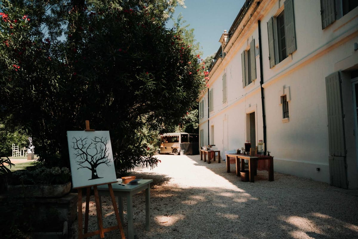 White manor courtyard with fingerprint guest book easel and vintage bar truck at far end