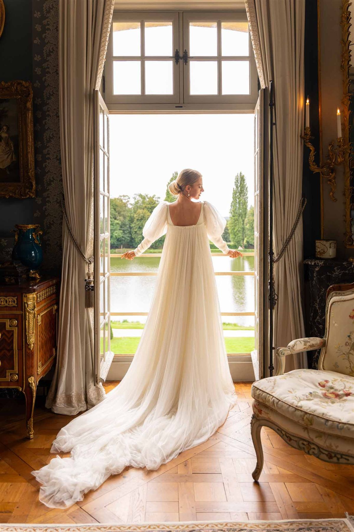 Bride at French doors with garden view at Chateau de Villette