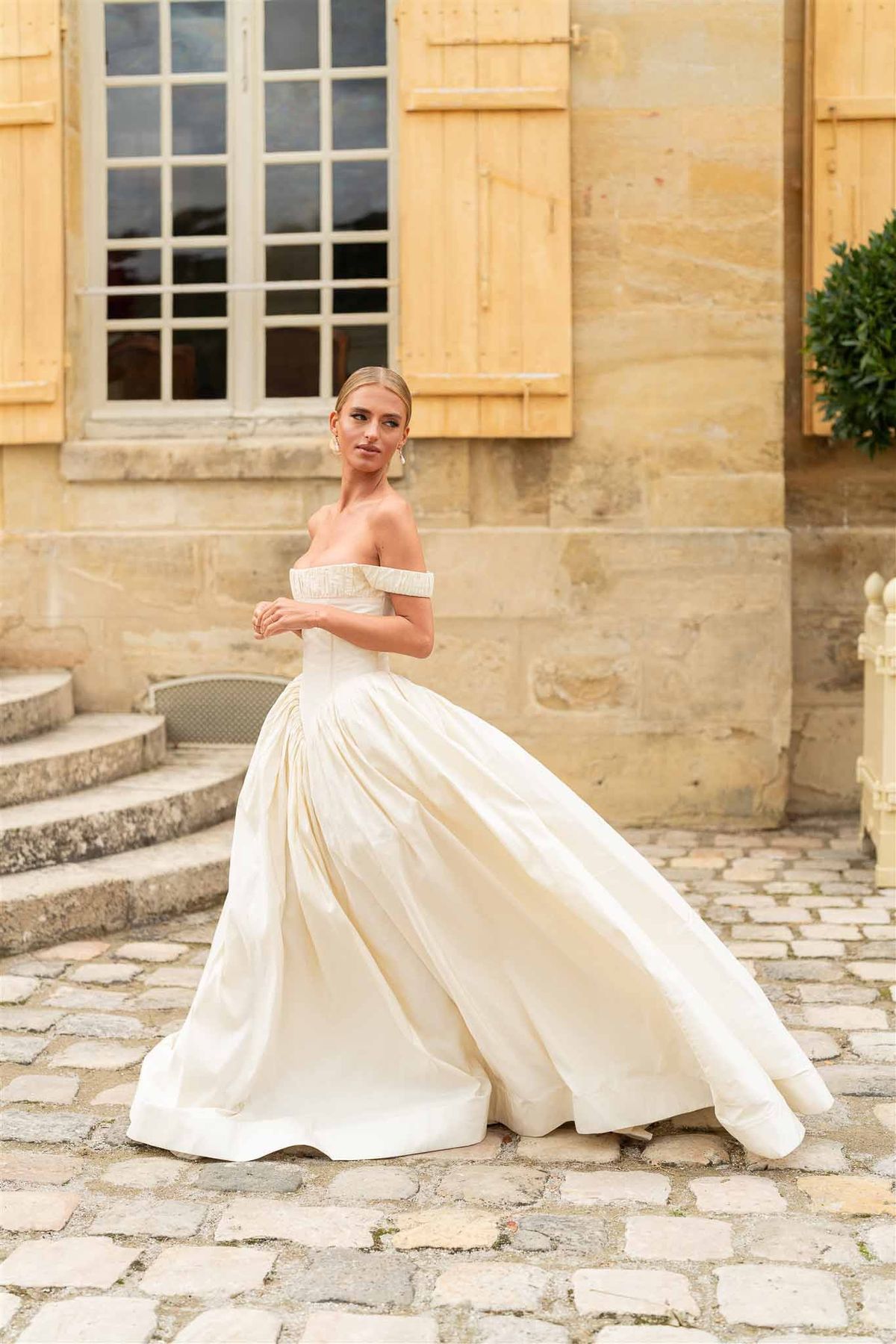 Bride in ball gown on courtyard steps at Chateau de Villette