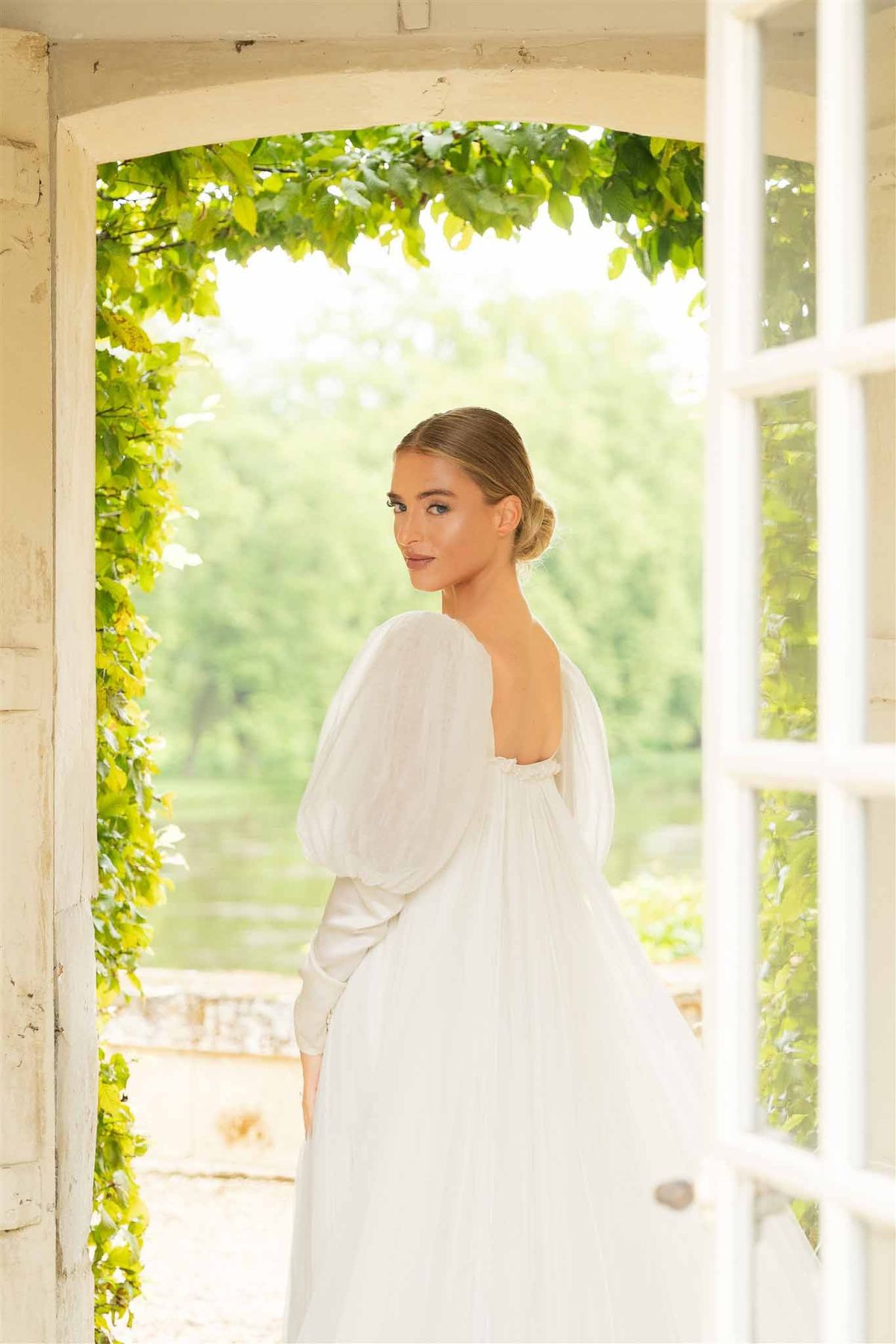 Bride in doorway with garden view at Chateau de Villette