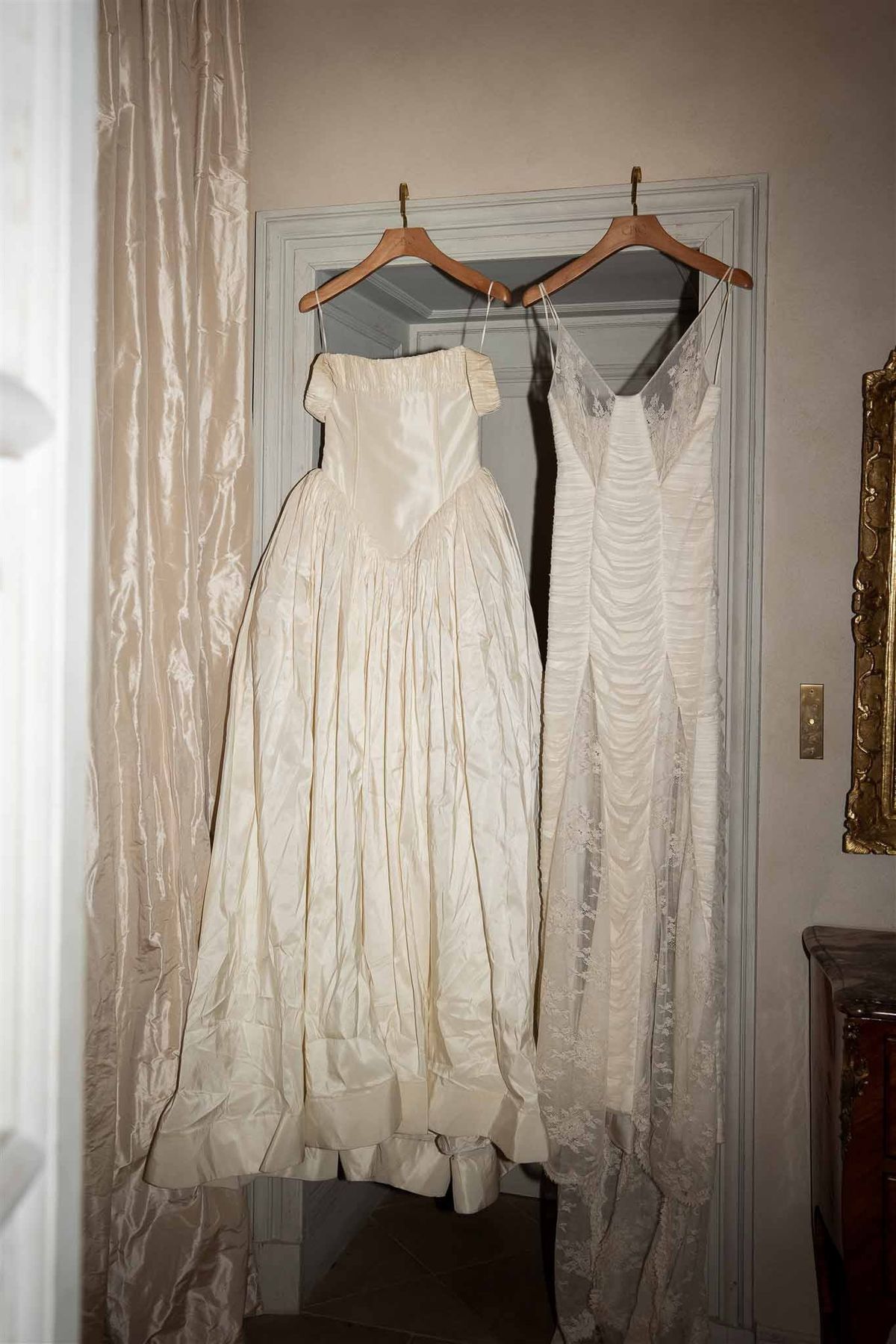 Two bridal gowns hanging in bedroom at Chateau de Villette