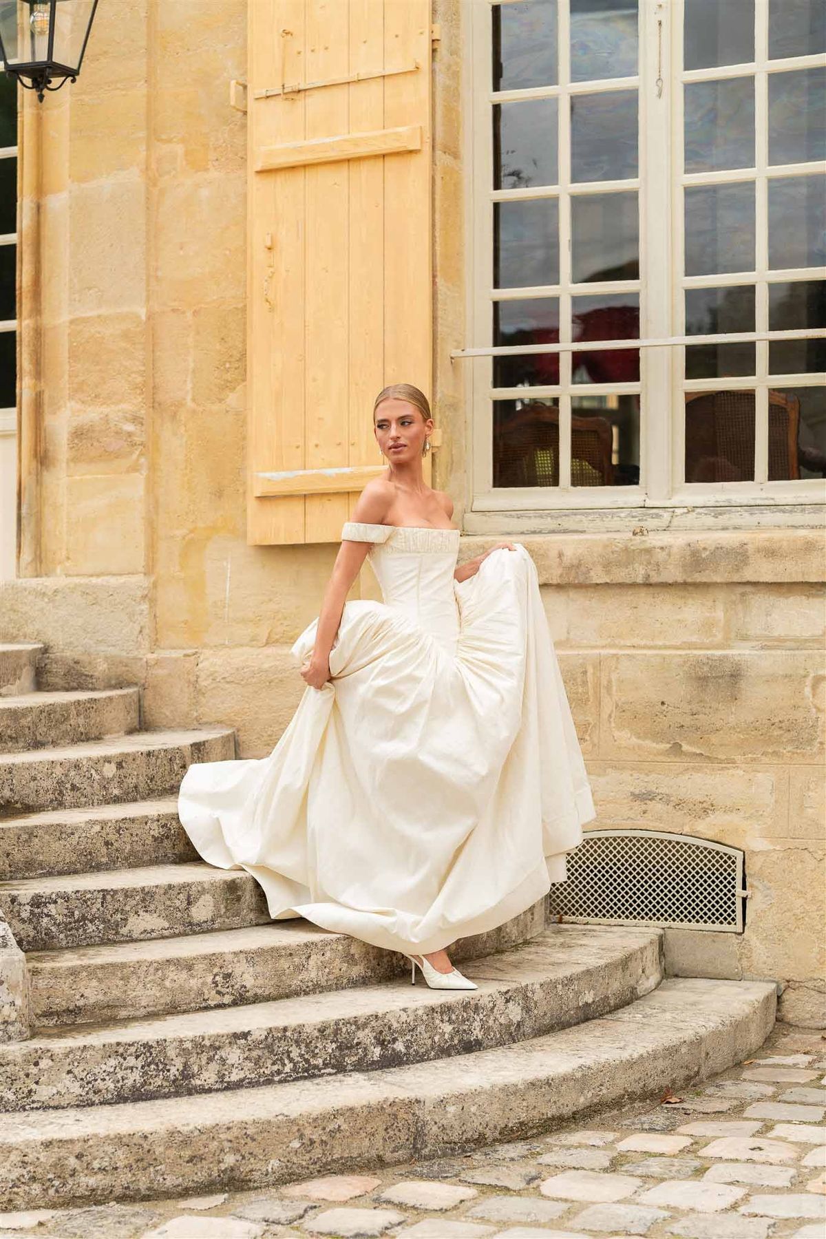 Bride descending stone steps at Chateau de Villette