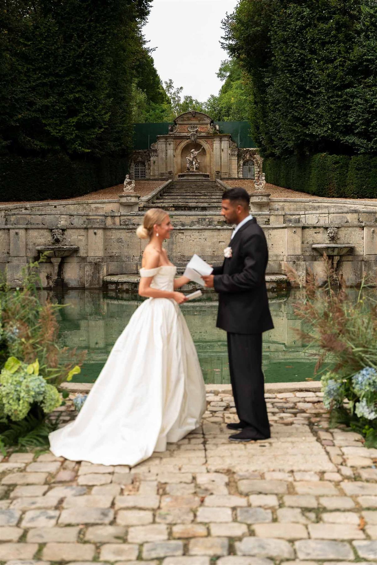 Ceremony at classical cascade and reflecting pool at Chateau de Villette