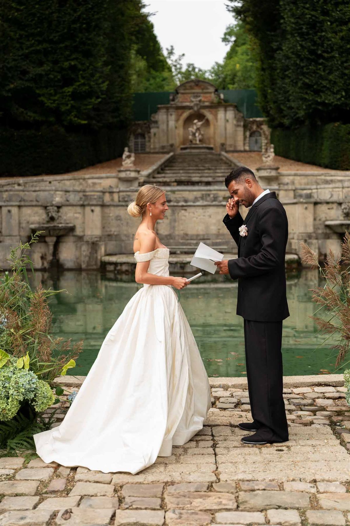 Emotional vow exchange at cascade fountain Chateau de Villette