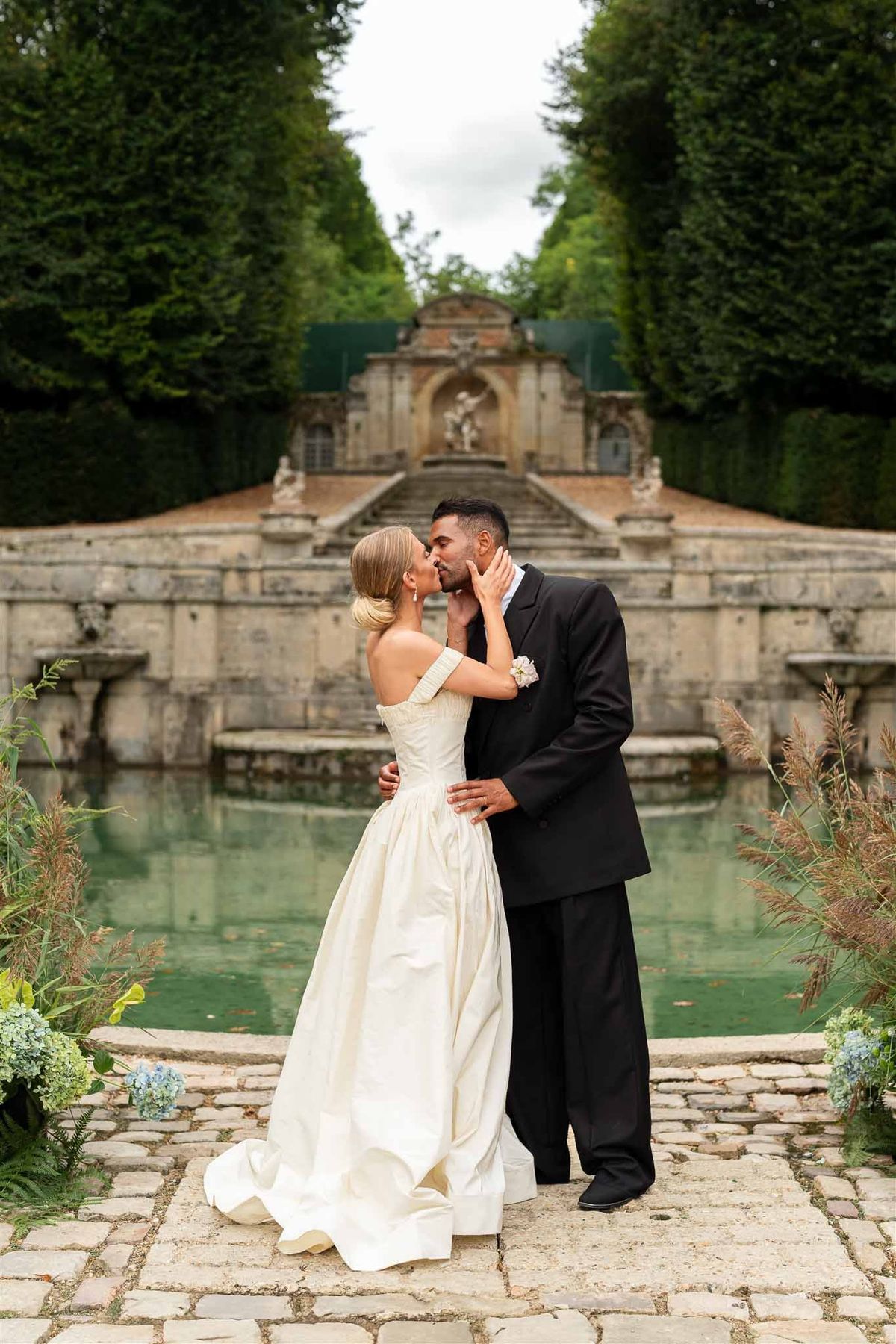 Couple kissing at cascade fountain at Chateau de Villette