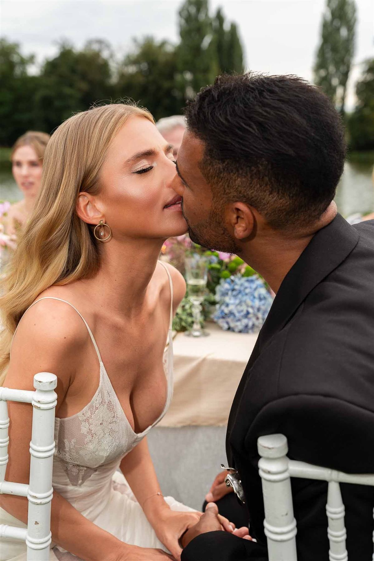 Couple kissing at lakeside reception at Chateau de Villette