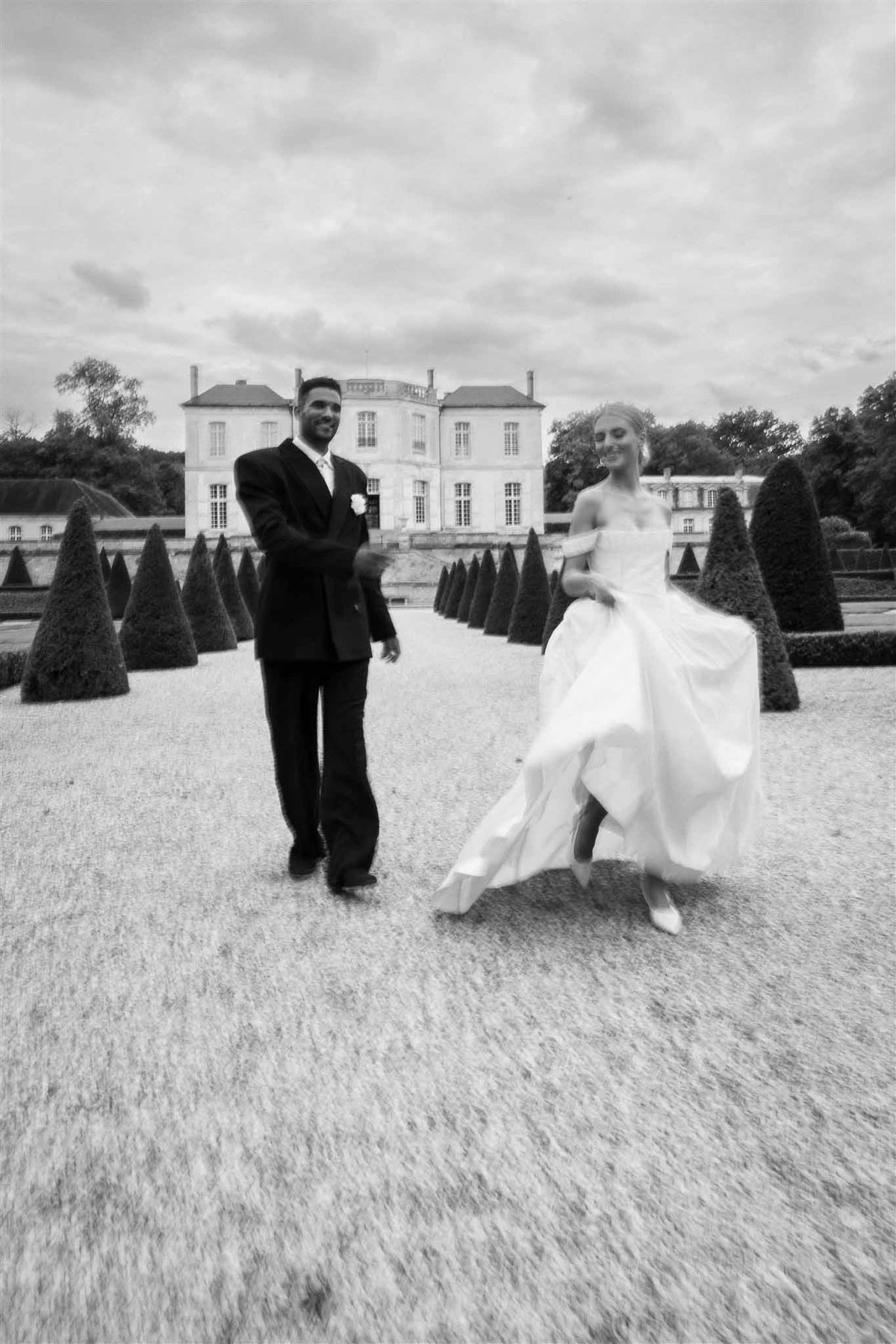 Couple walking through parterre garden at Chateau de Villette