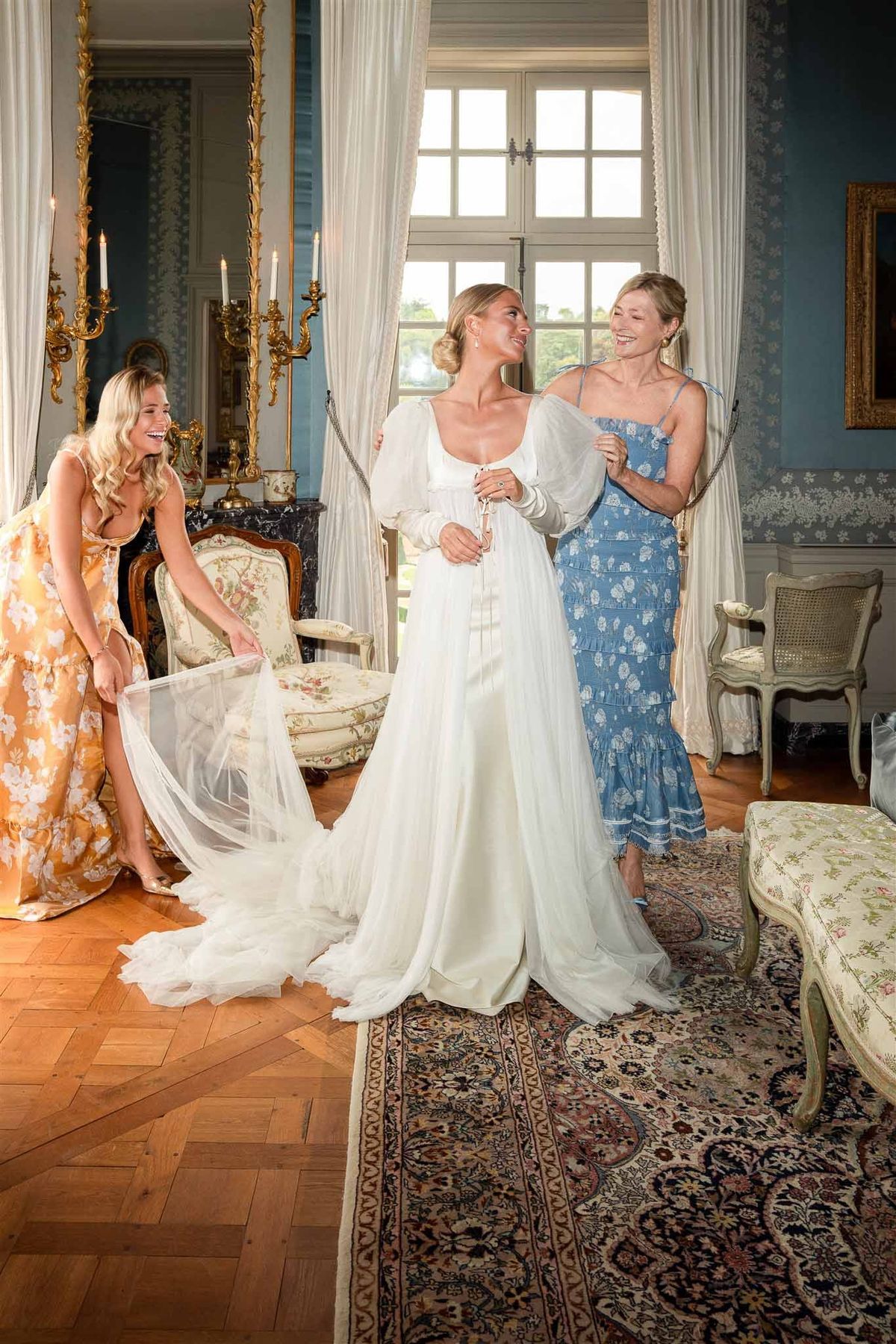 Bride with bridesmaids getting ready in blue salon at Chateau de Villette
