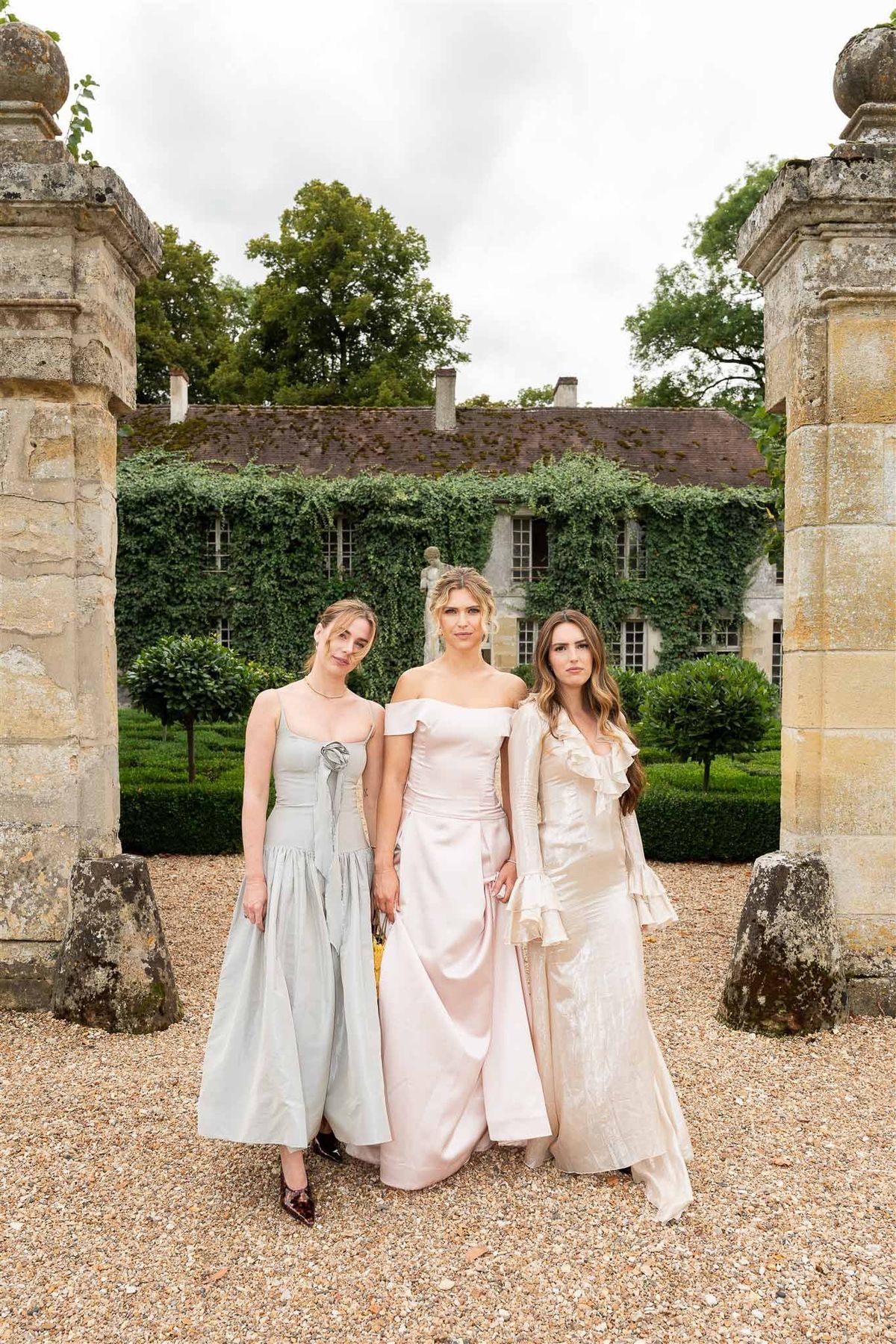 Bridesmaids walking through stone gateway at Chateau de Villette