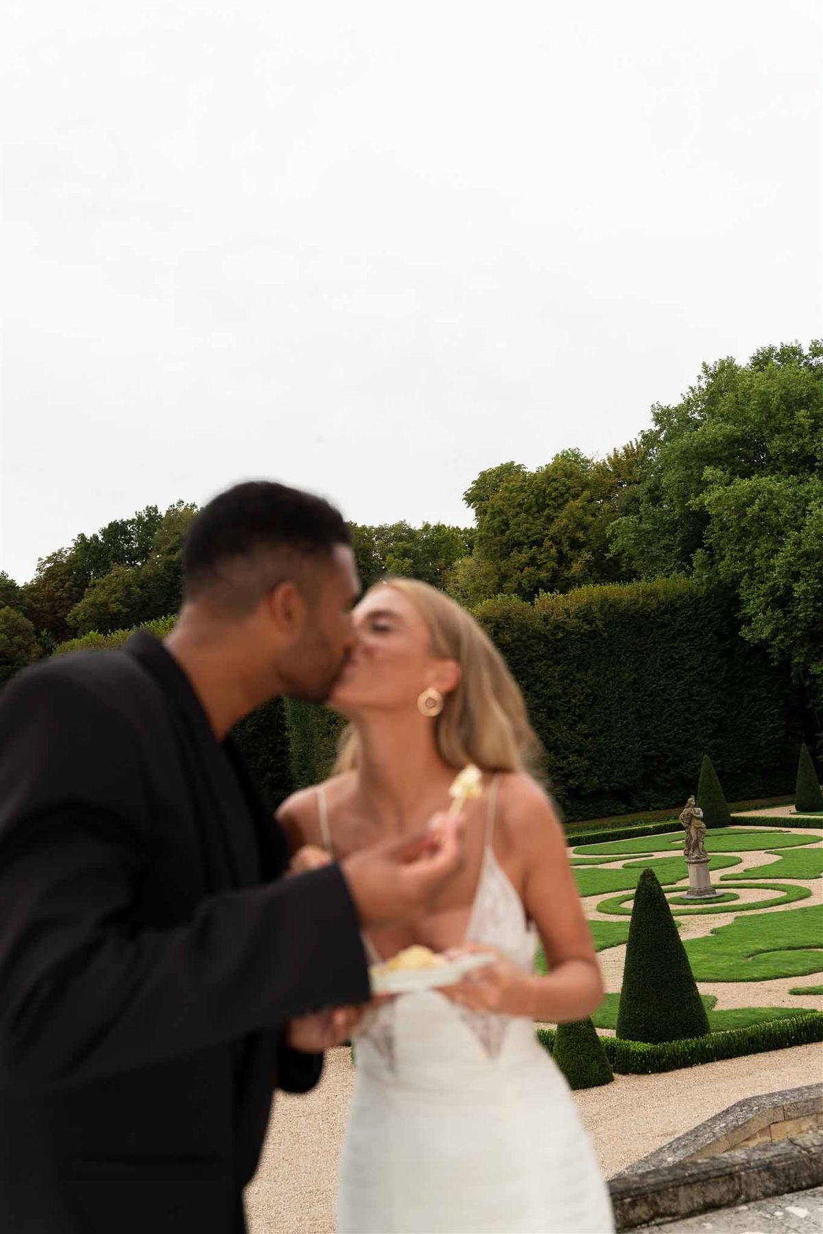 Couple kissing with parterre gardens at Chateau de Villette