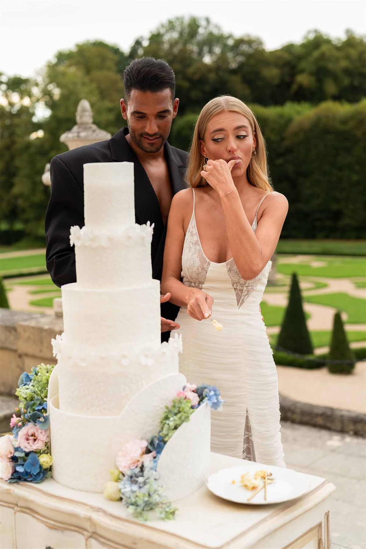 Couple tasting wedding cake at Chateau de Villette