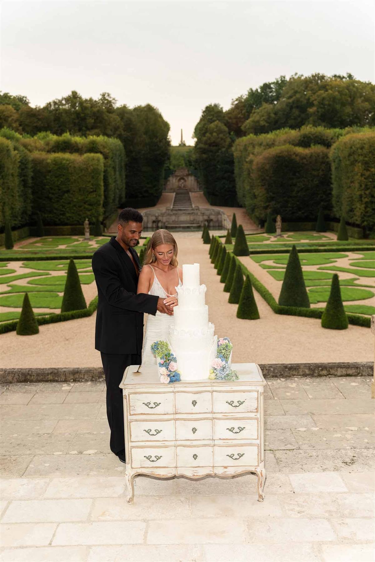 Cake cutting overlooking parterre gardens at Chateau de Villette