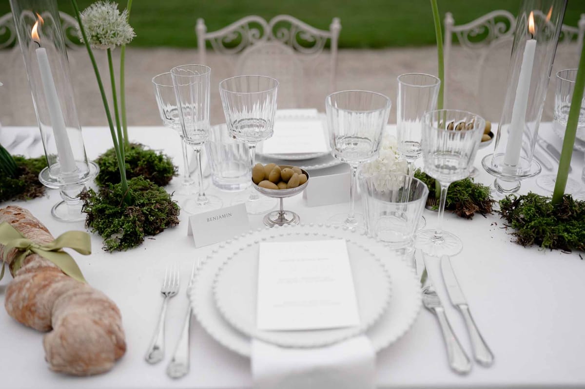 Reception table with food, floral centerpiece, and lit candles