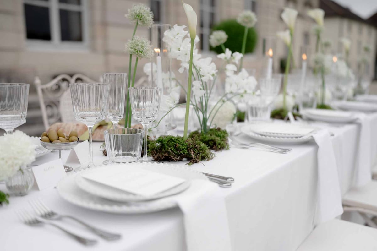 Table setting detail showing centerpiece, flowers, and candlelight
