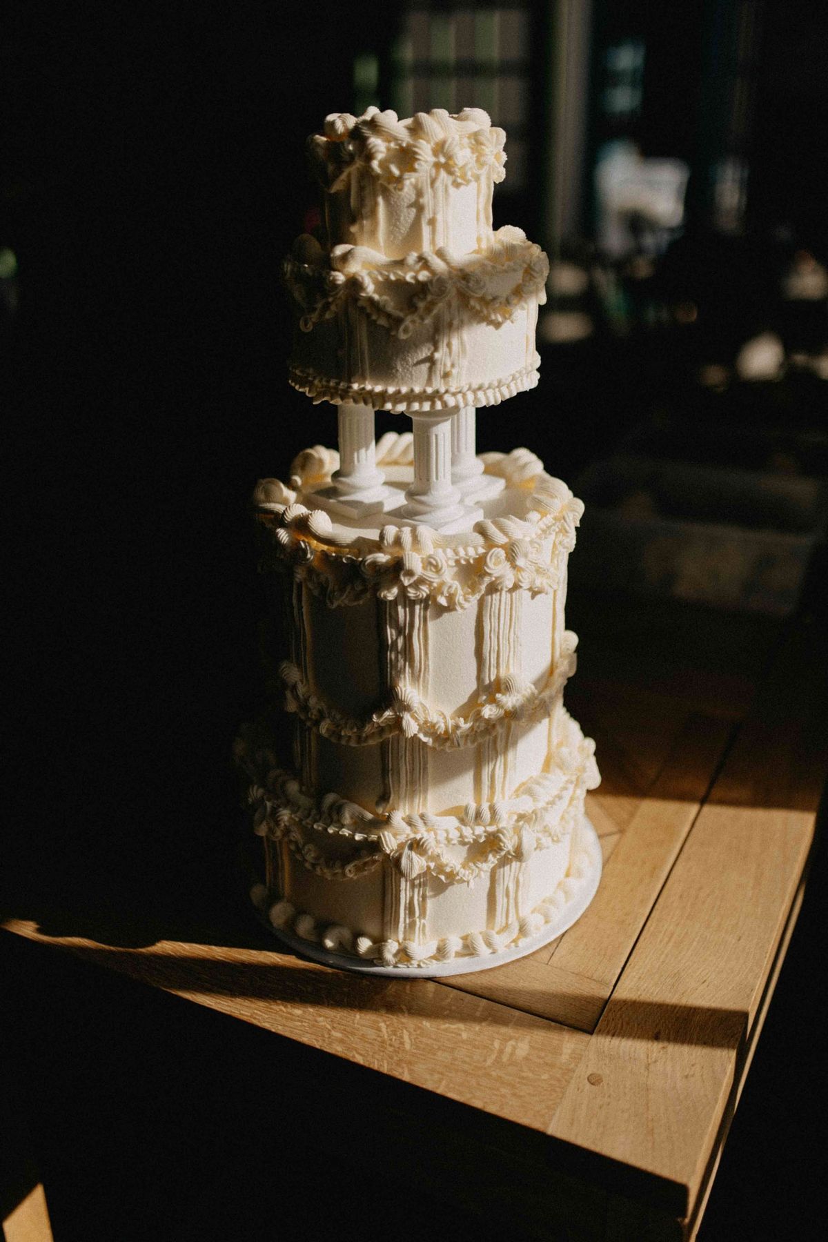 Vintage piping detail on a tiered cake with sugared fruit and trailing amaranthus