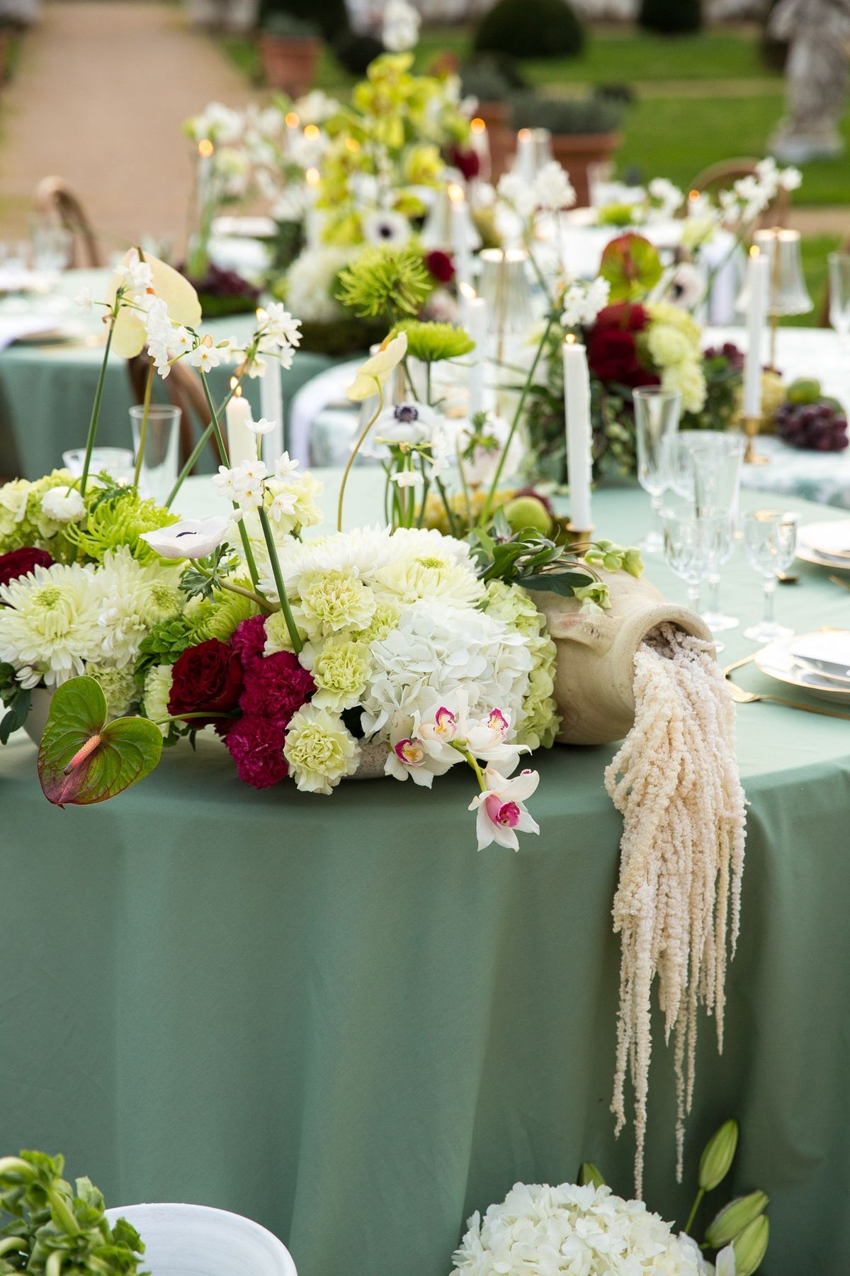 Hero centerpiece with hydrangeas, anthurium, chrysanthemums and roses spilling on moss bed