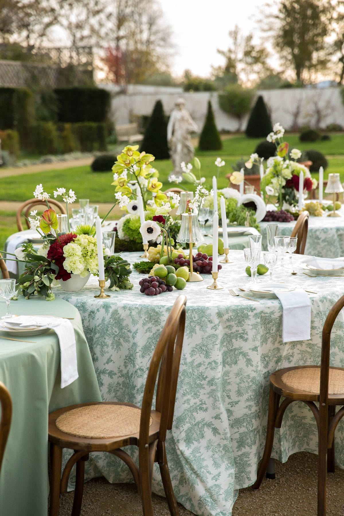 Long banquet table from above with cascading florals, bentwood chairs and toile cloth in parterre