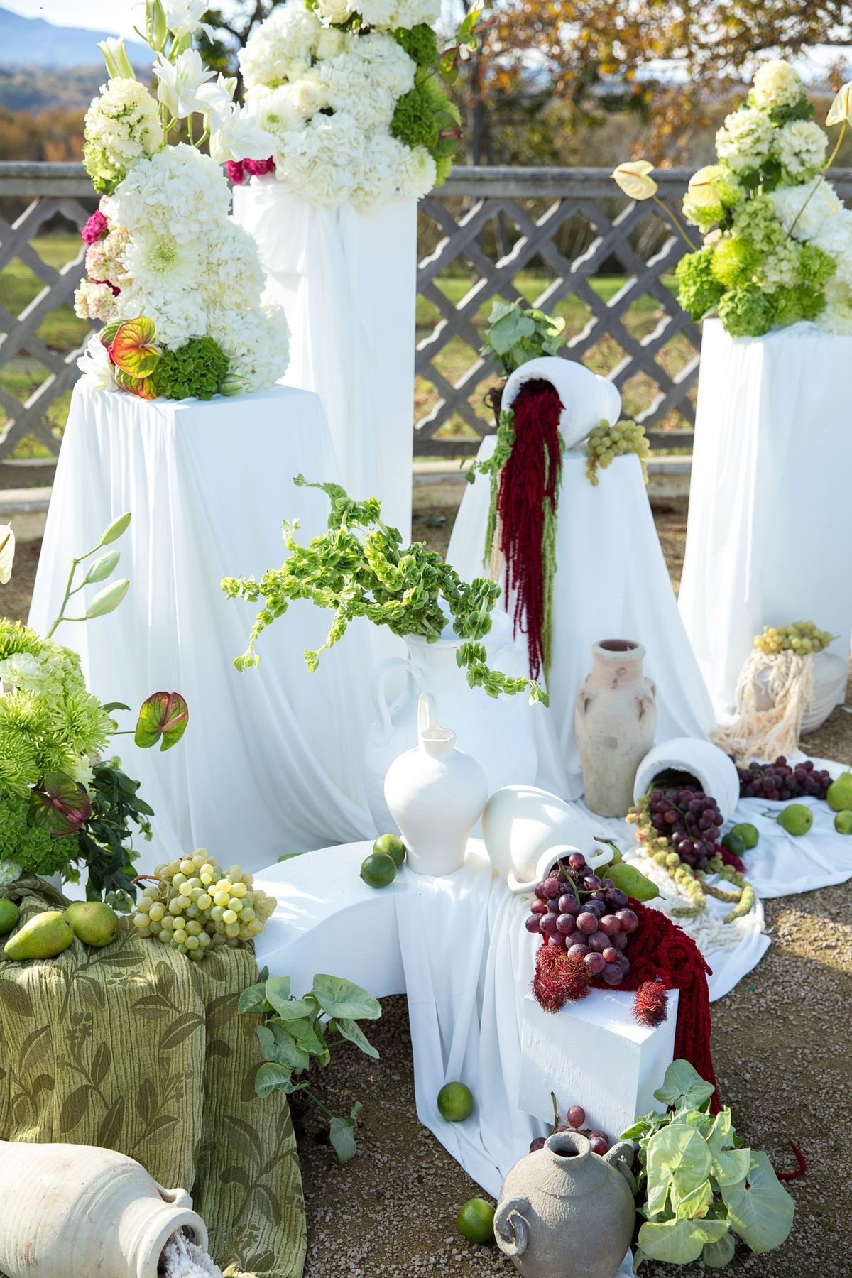 Ceremony backdrop with cascading hydrangeas, terracotta vessels and burgundy amaranthus on white drape