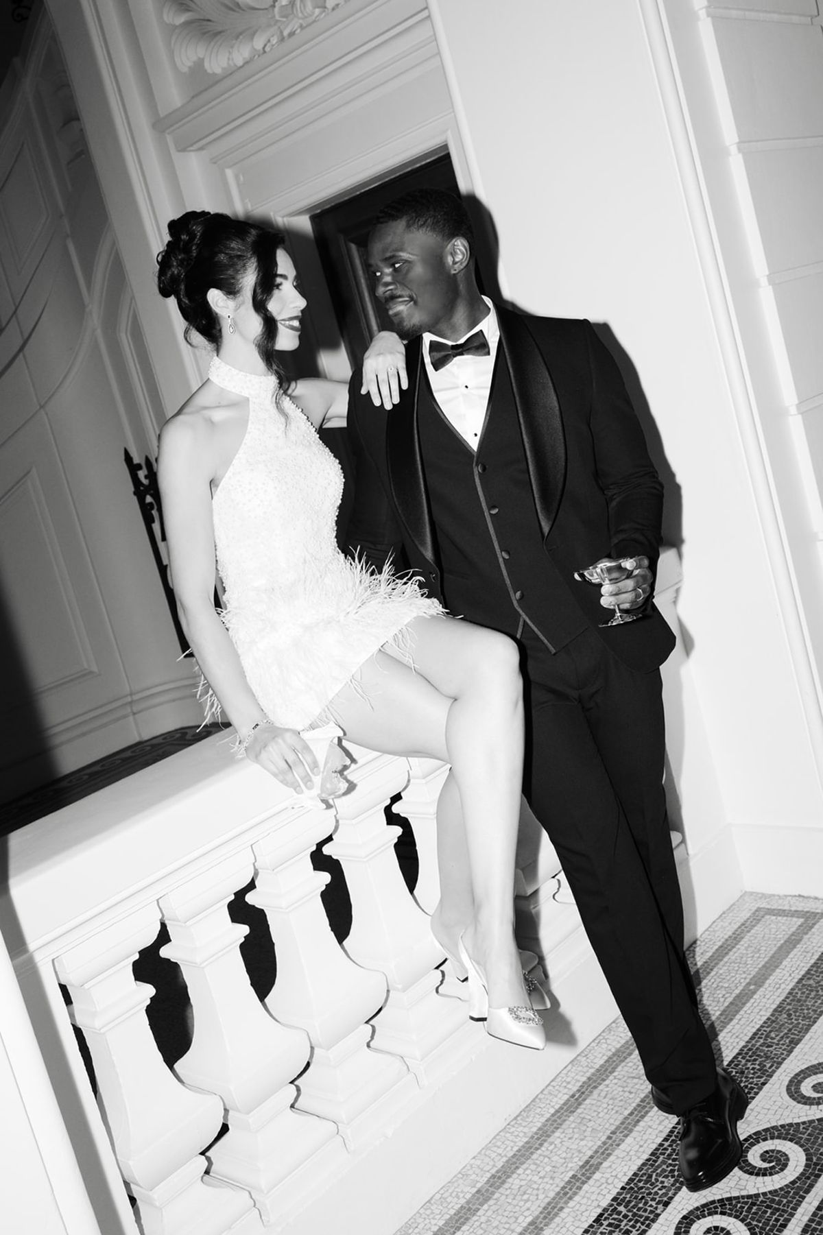 Couple seated inside Domaine des Halles in after-party attire black and white
