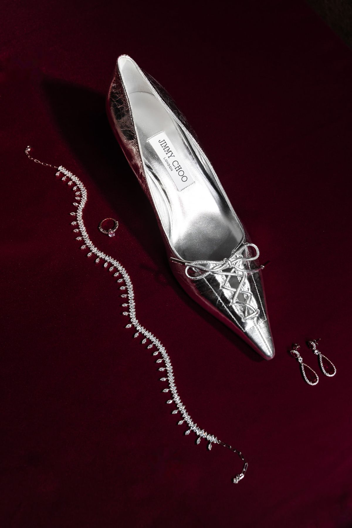 Silver Jimmy Choo shoe with diamond necklace on red velvet at Domaine des Halles